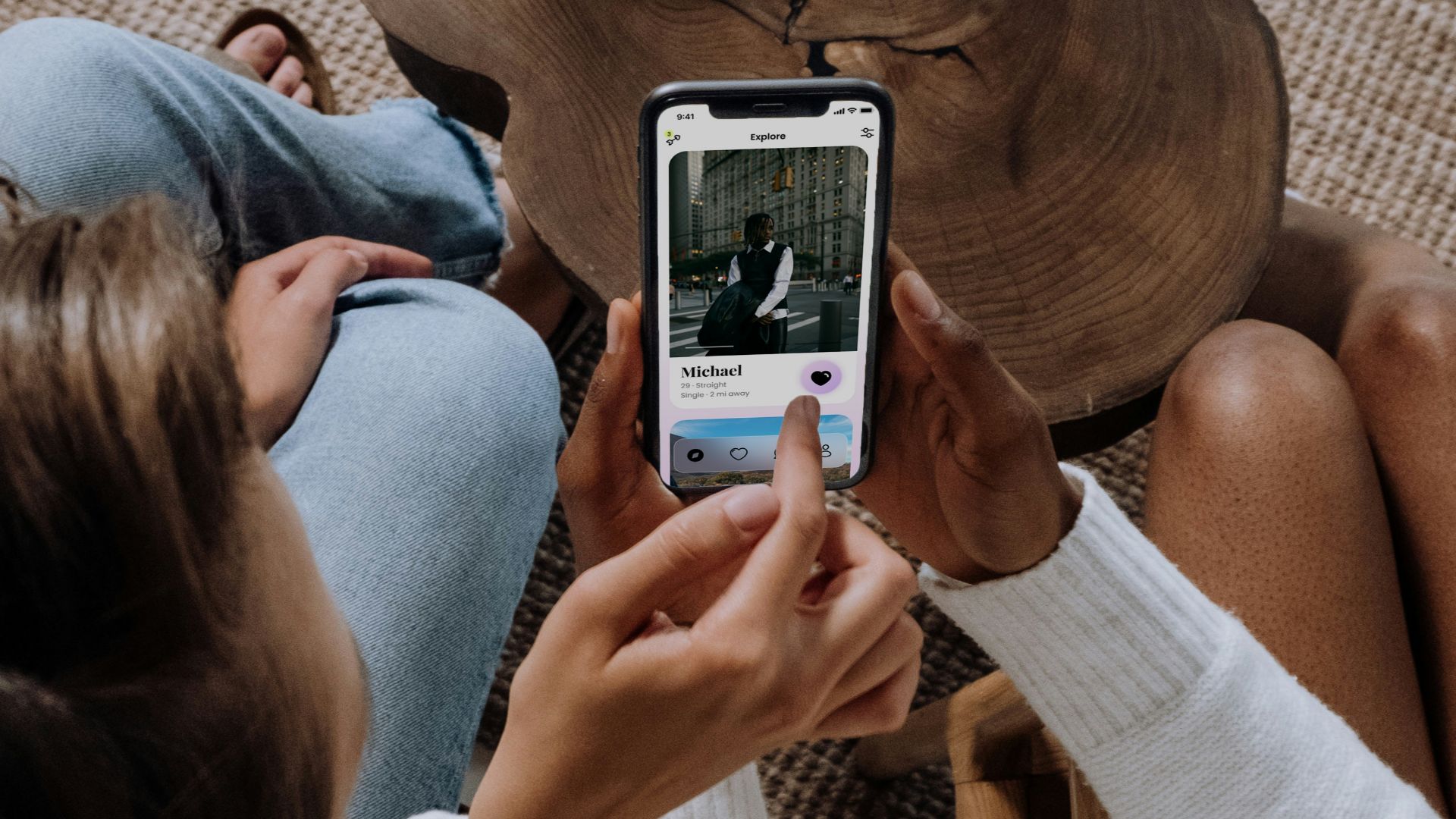 two women sitting on a couch looking at a cell phone