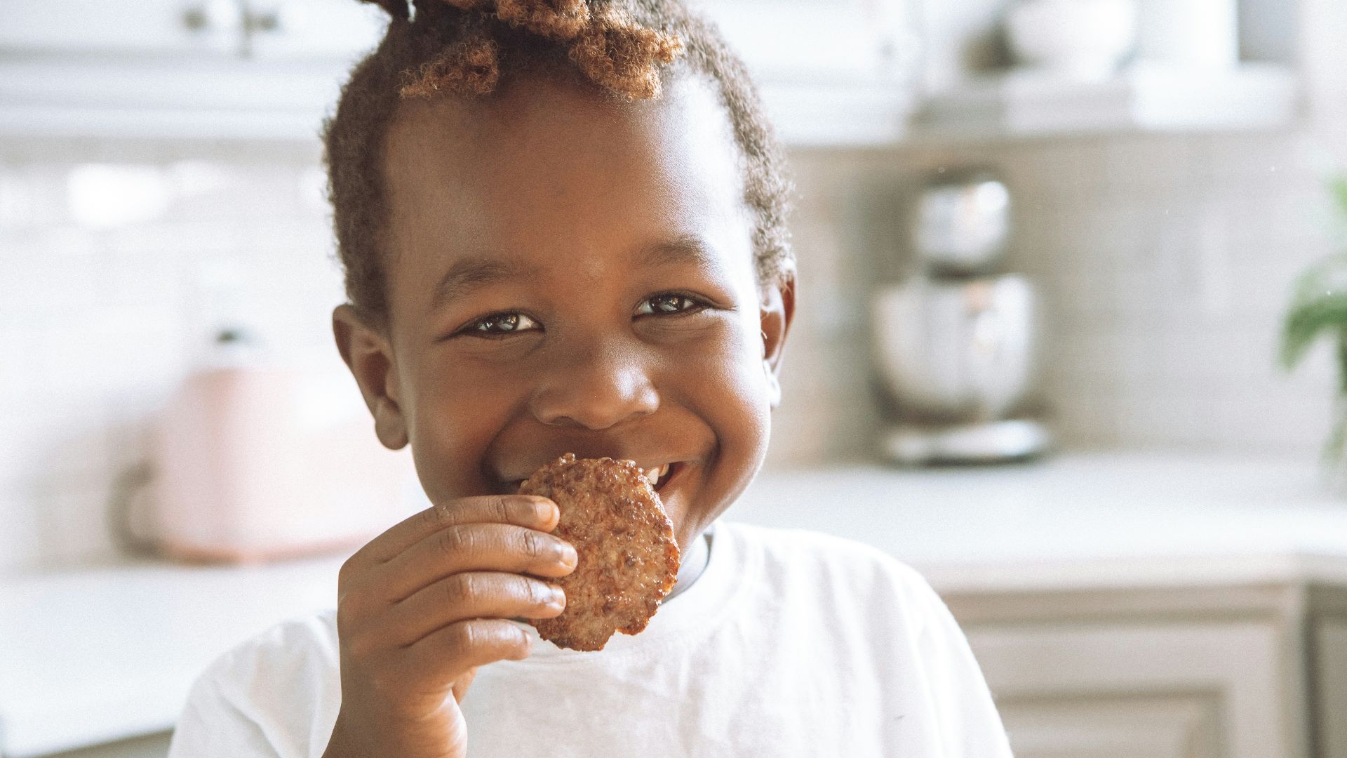 girl in white shirt holding brown bread
