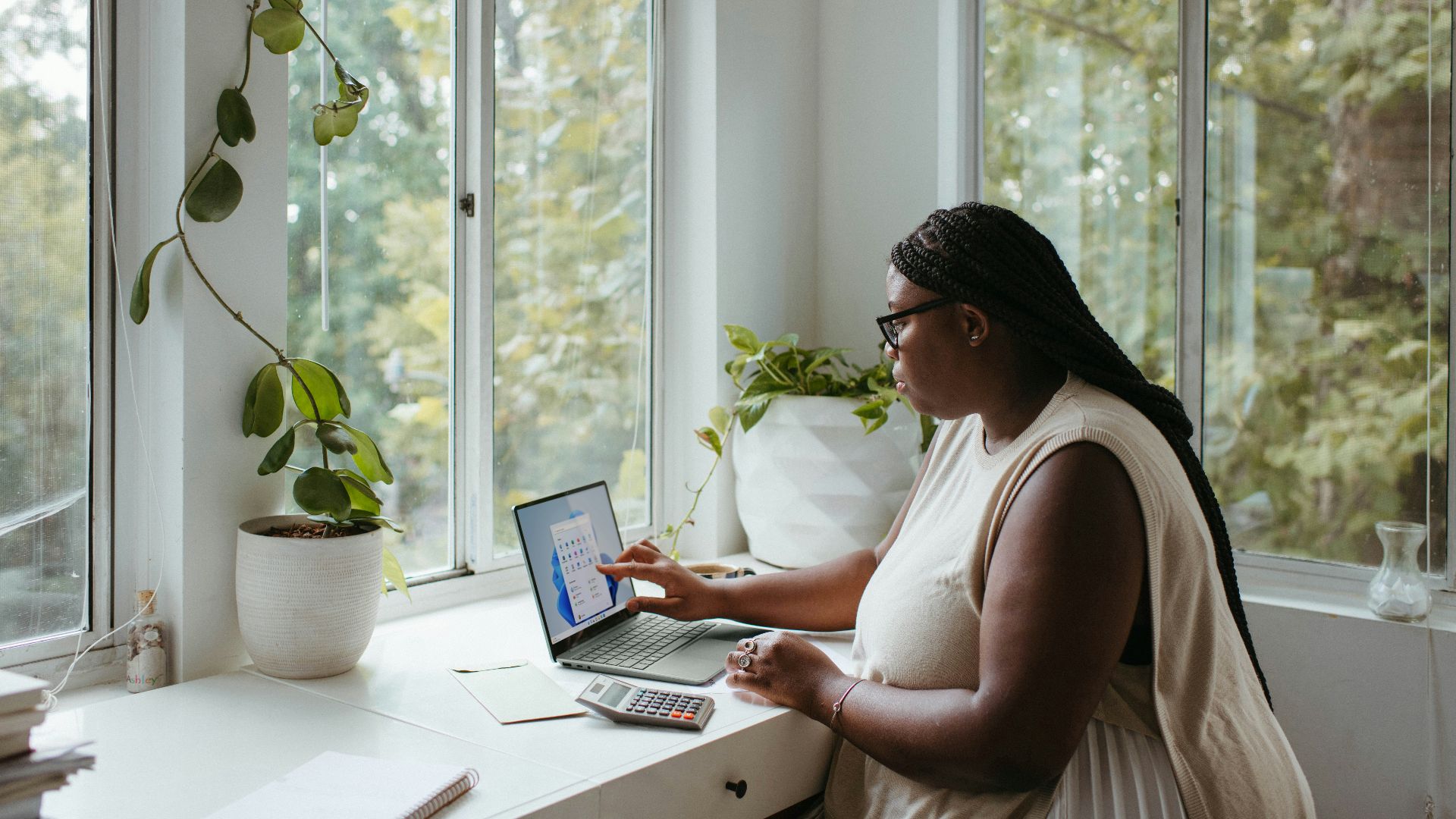 a woman sitting at a table with a laptop