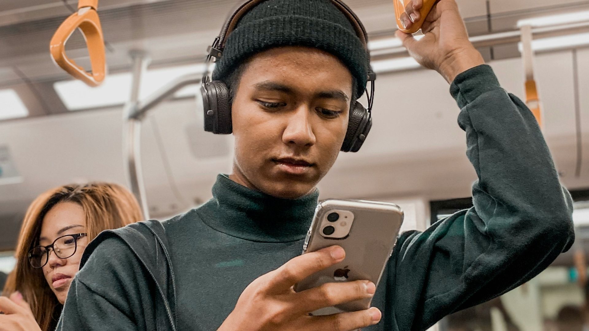 man in train holding smartphone