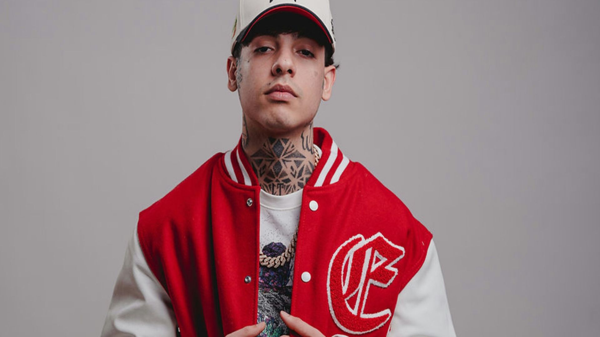 Young man in baseball cap and varsity jacket