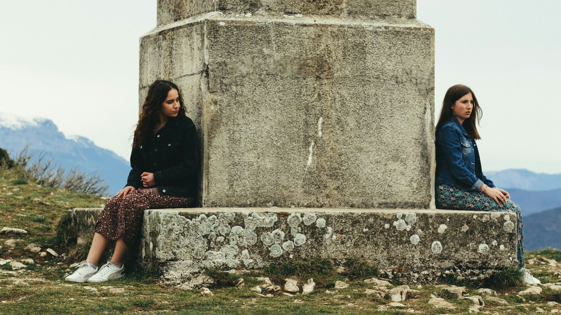 woman in black jacket sitting beside woman in black jacket