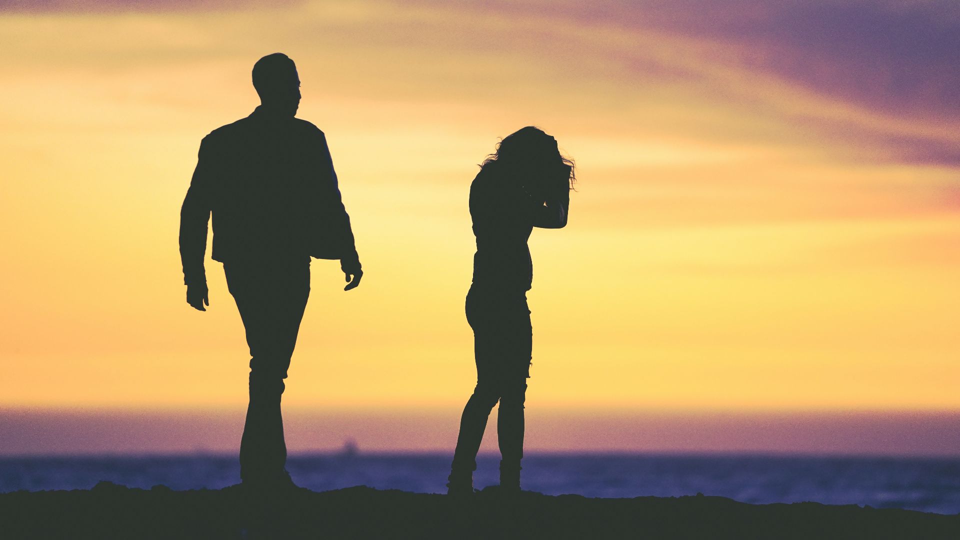 silhouette of man and woman under yellow sky