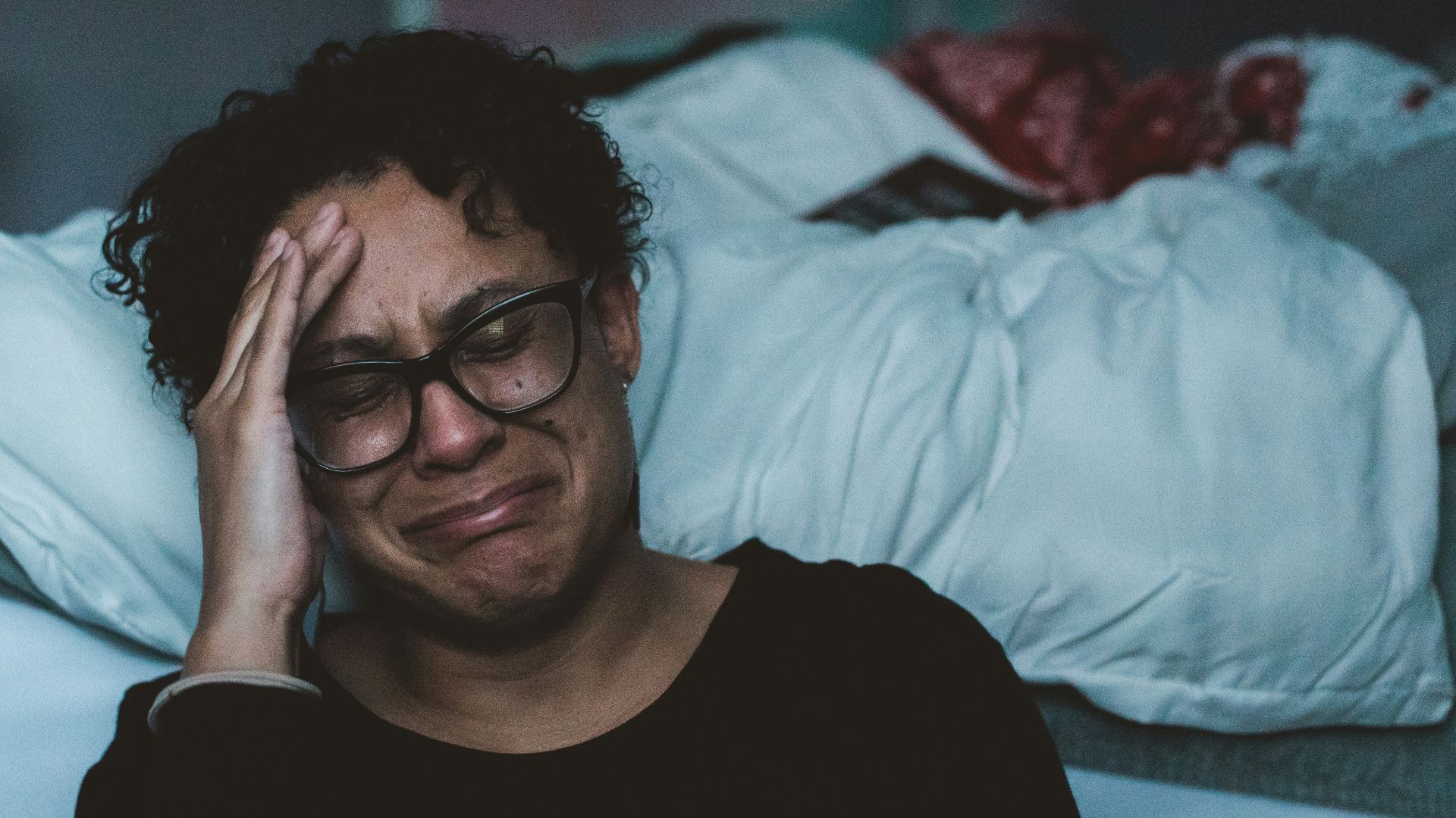 person crying beside bed