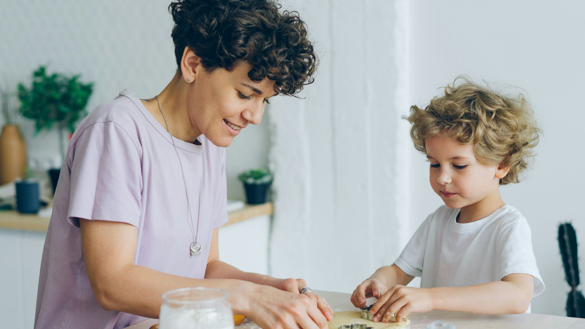 a woman and a child are making cookies