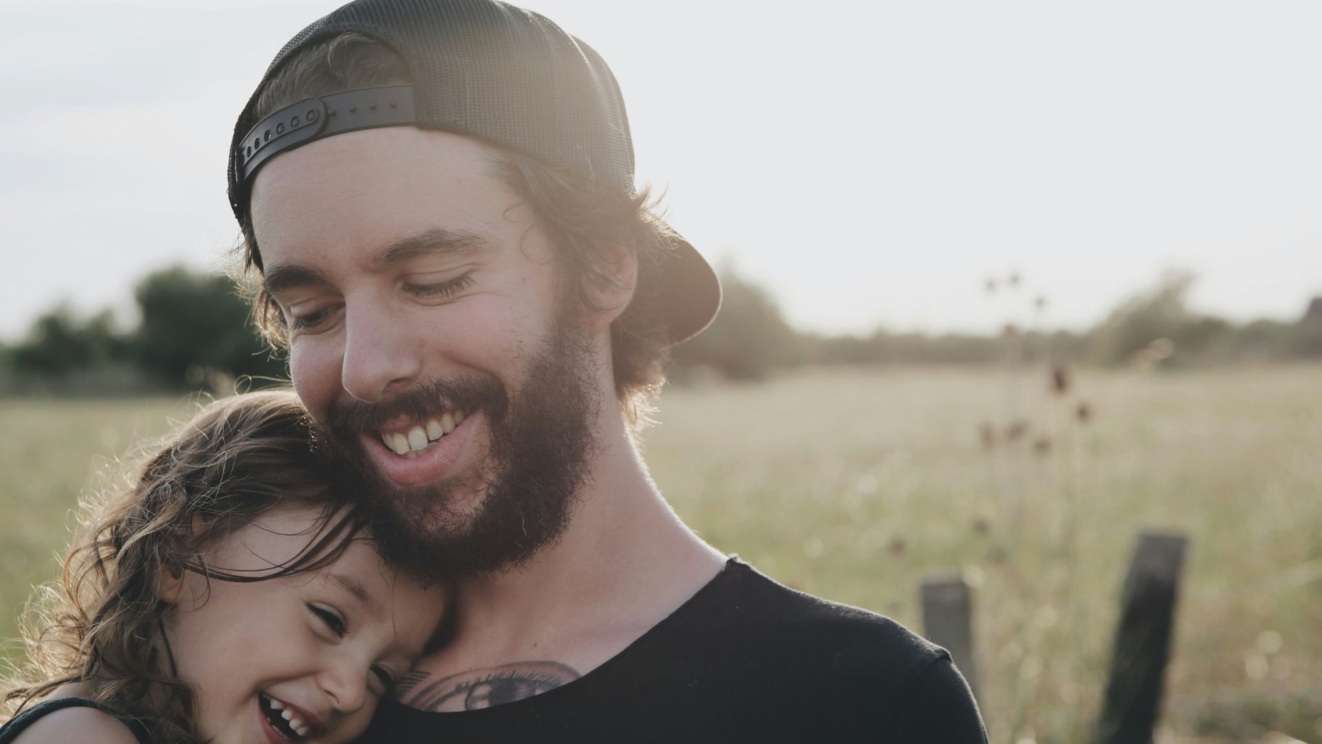 man carrying daughter in black sleeveless top