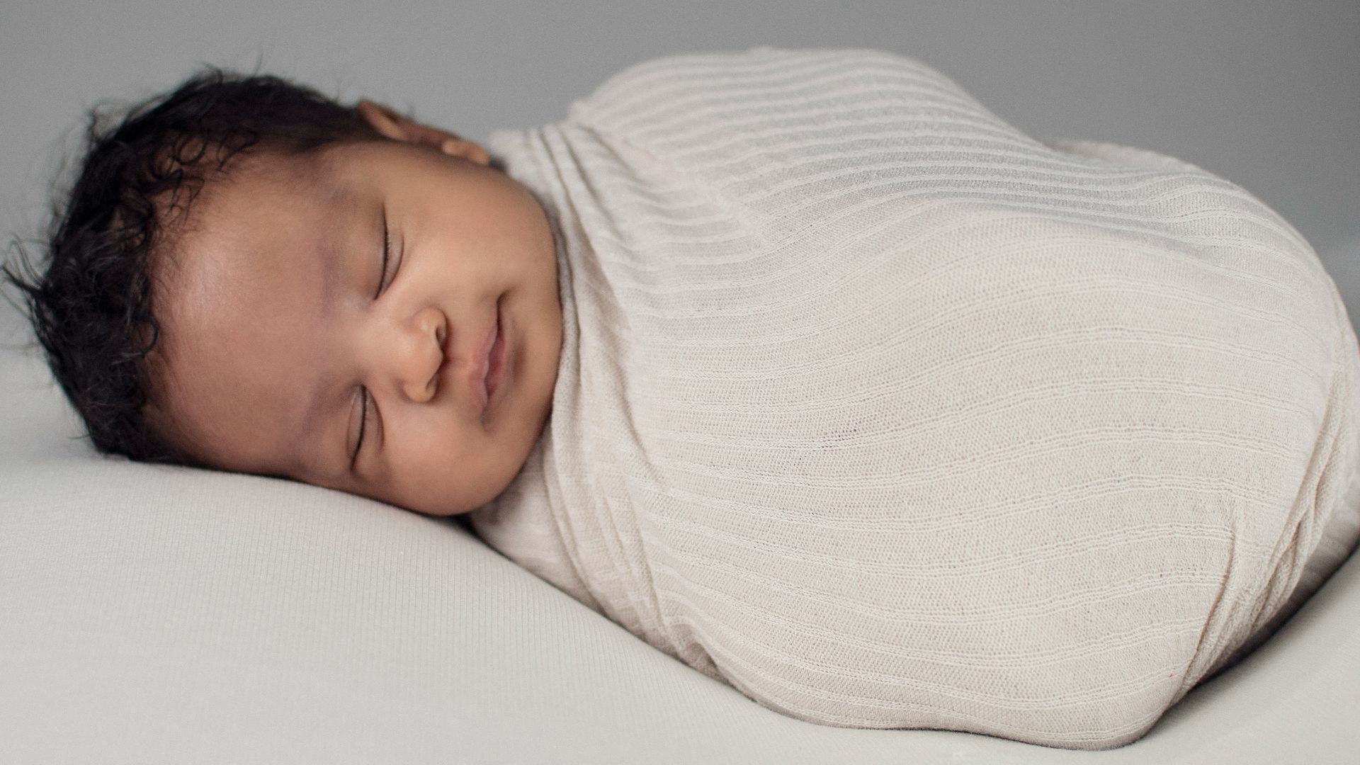 woman in white knit sweater lying on bed