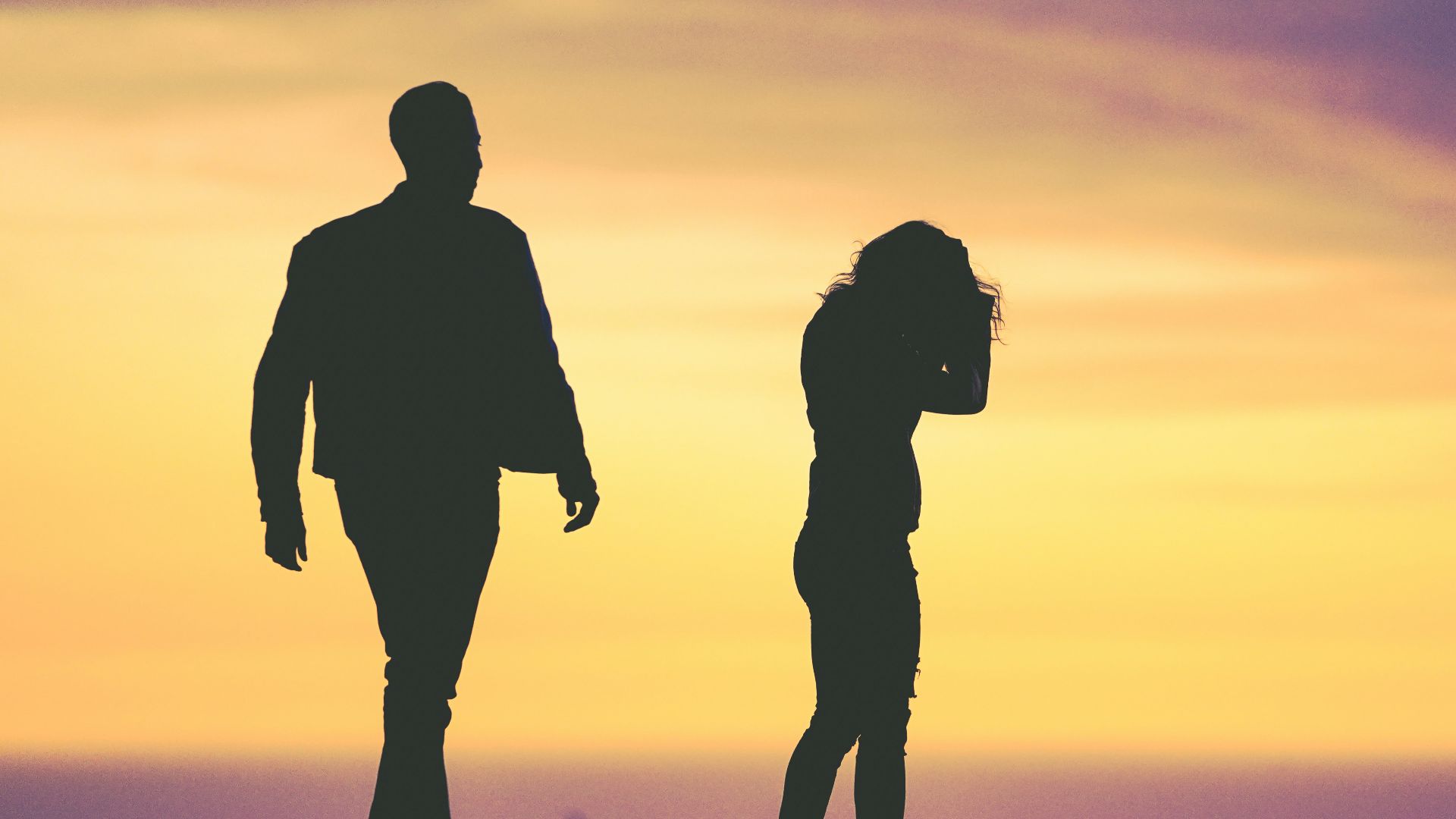silhouette of man and woman under yellow sky