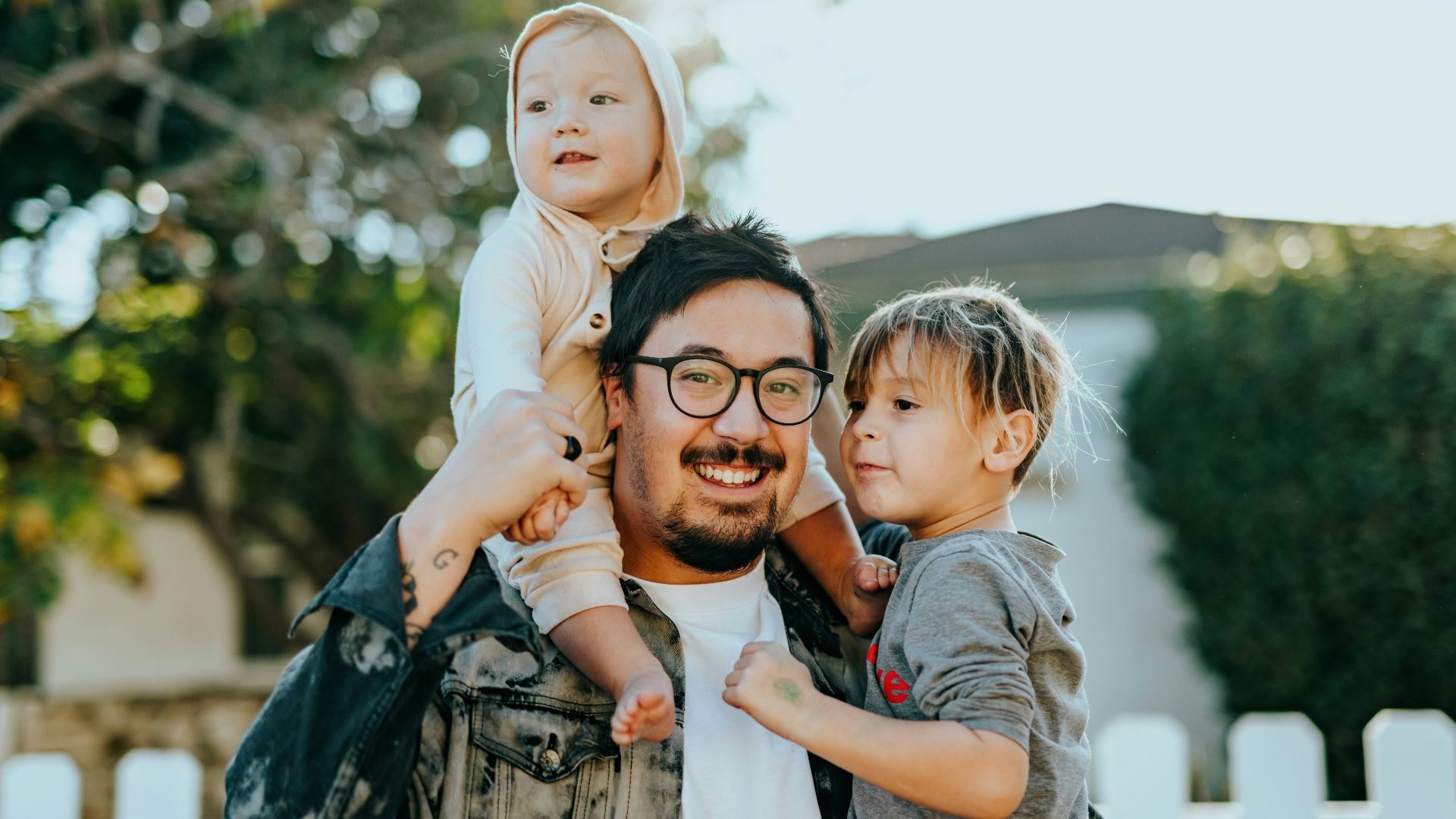 man in white shirt carrying girl in gray shirt