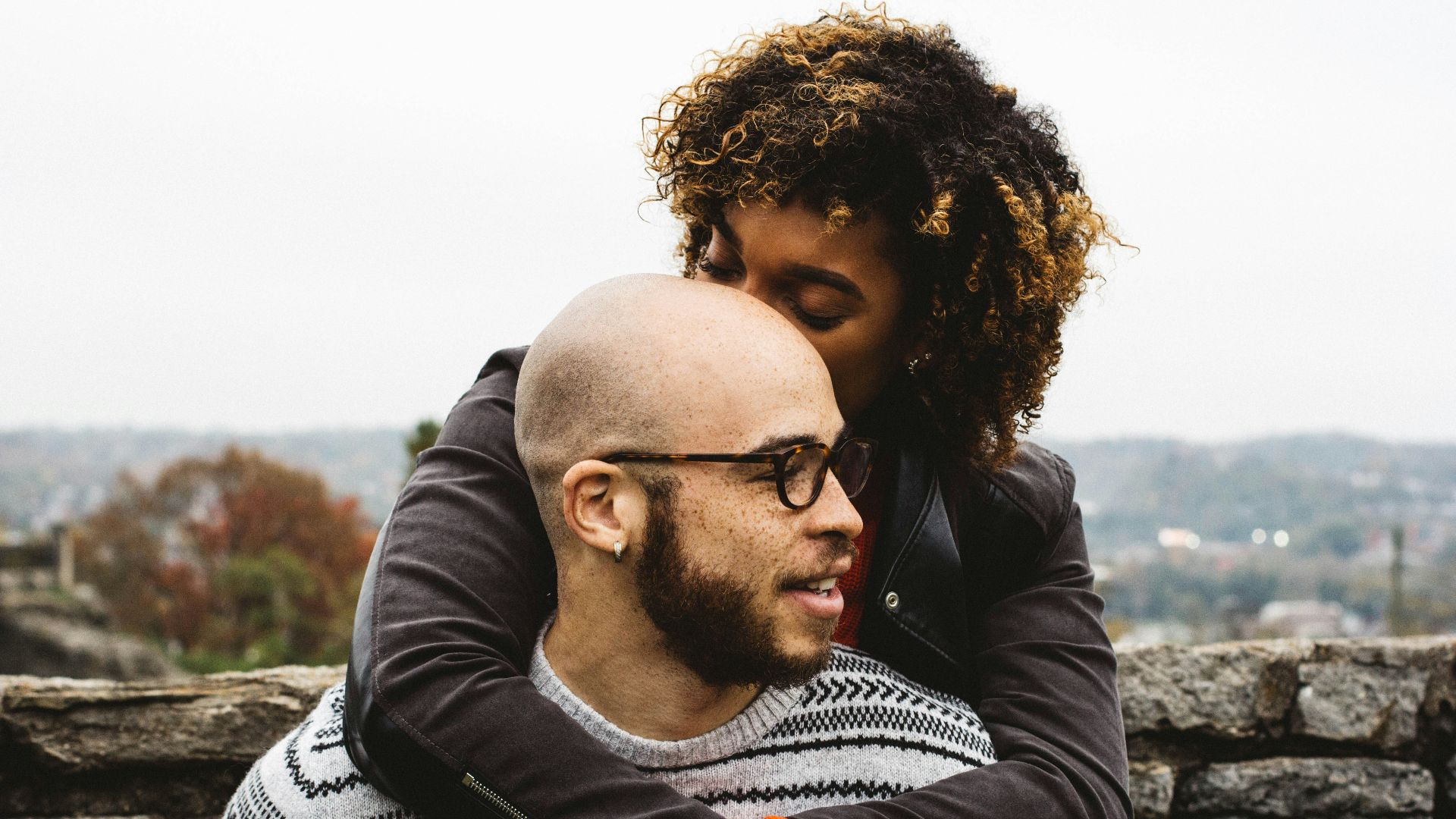 woman kissing man's head