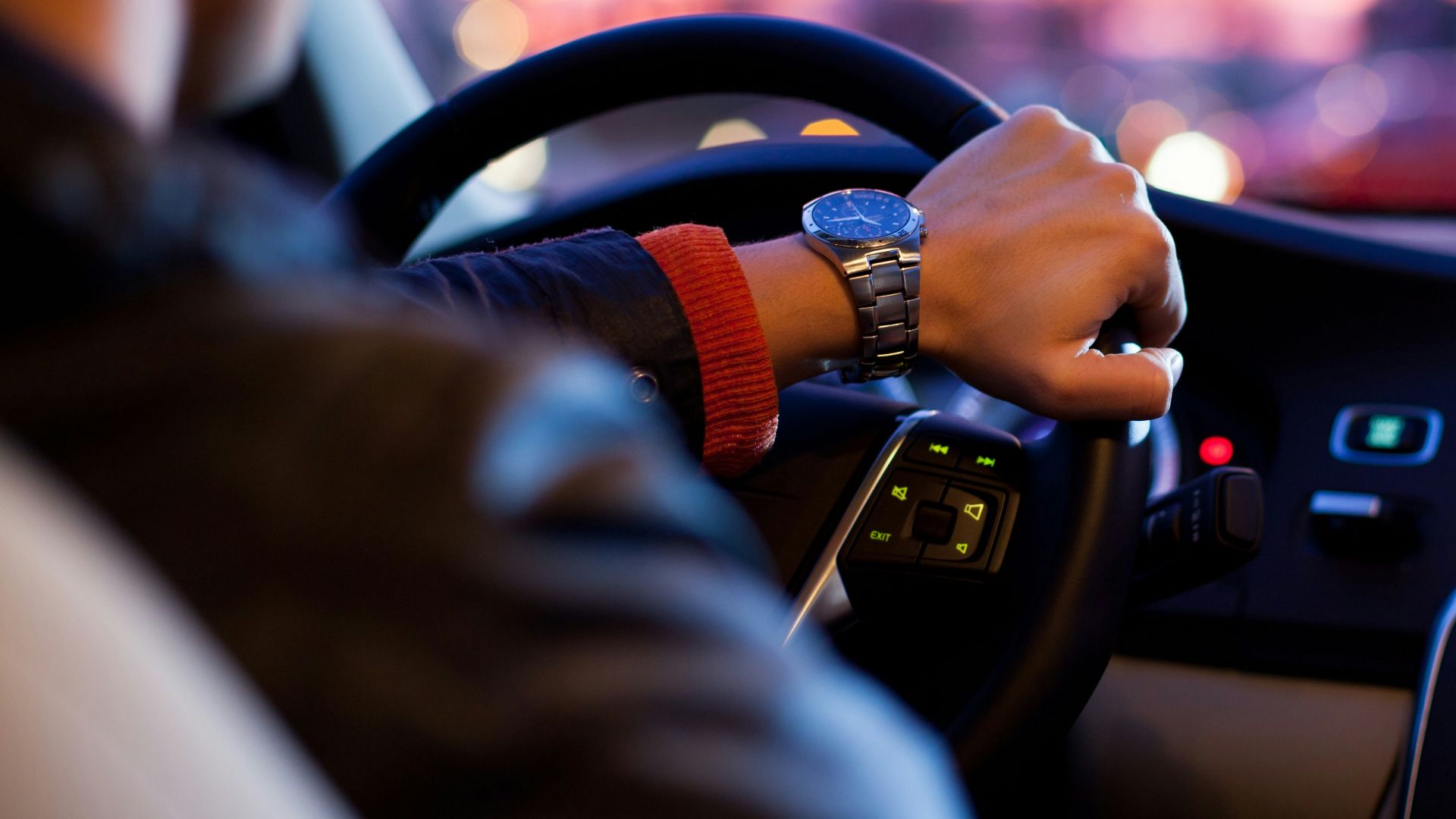 man driving a car wearing wrist watch