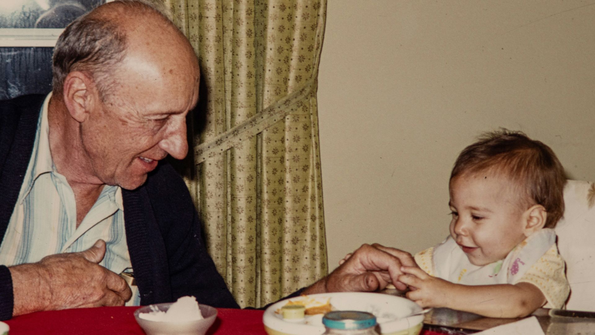 an older man and a young child sitting at a table