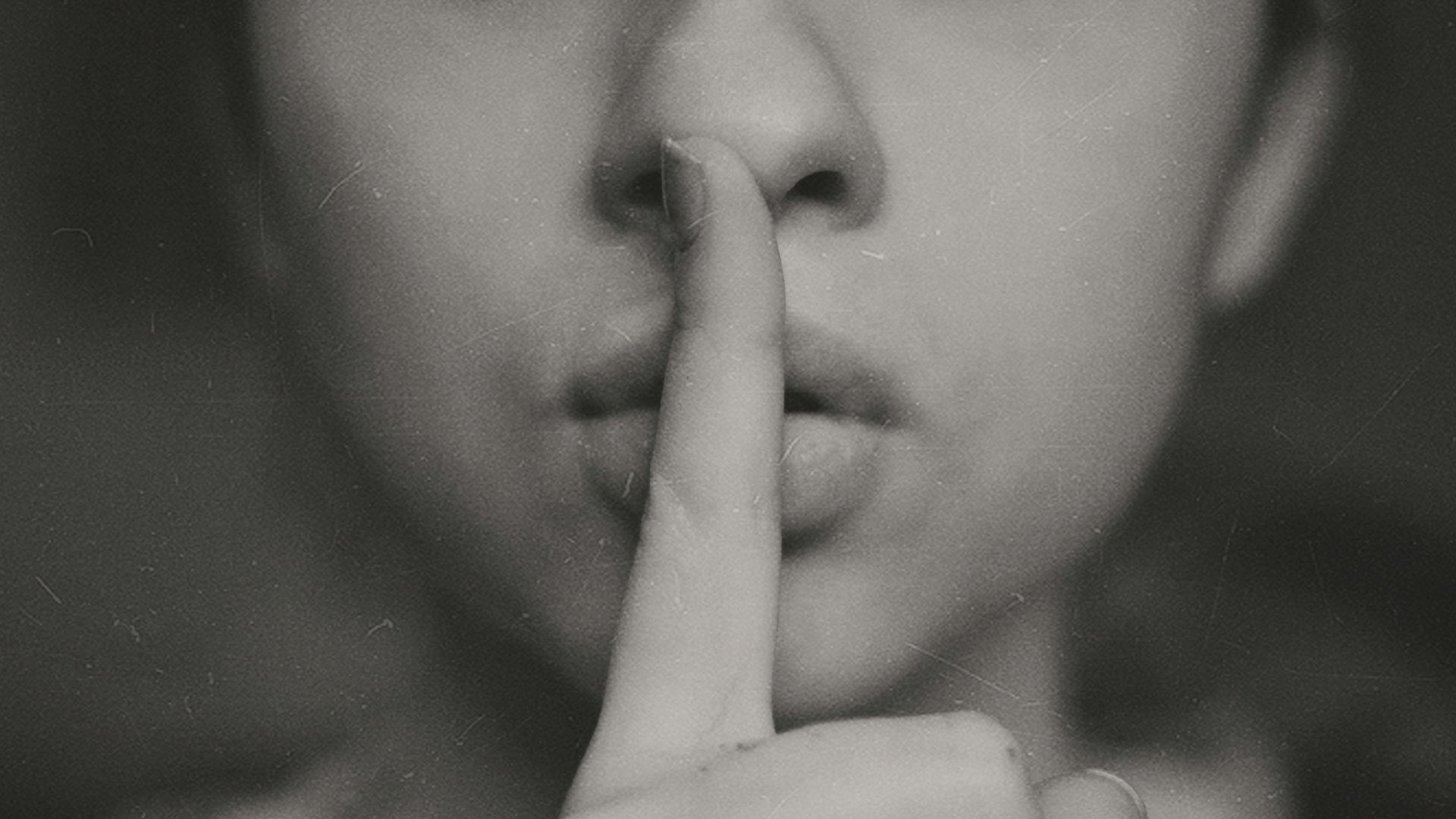 grayscale photo of woman doing silent hand sign