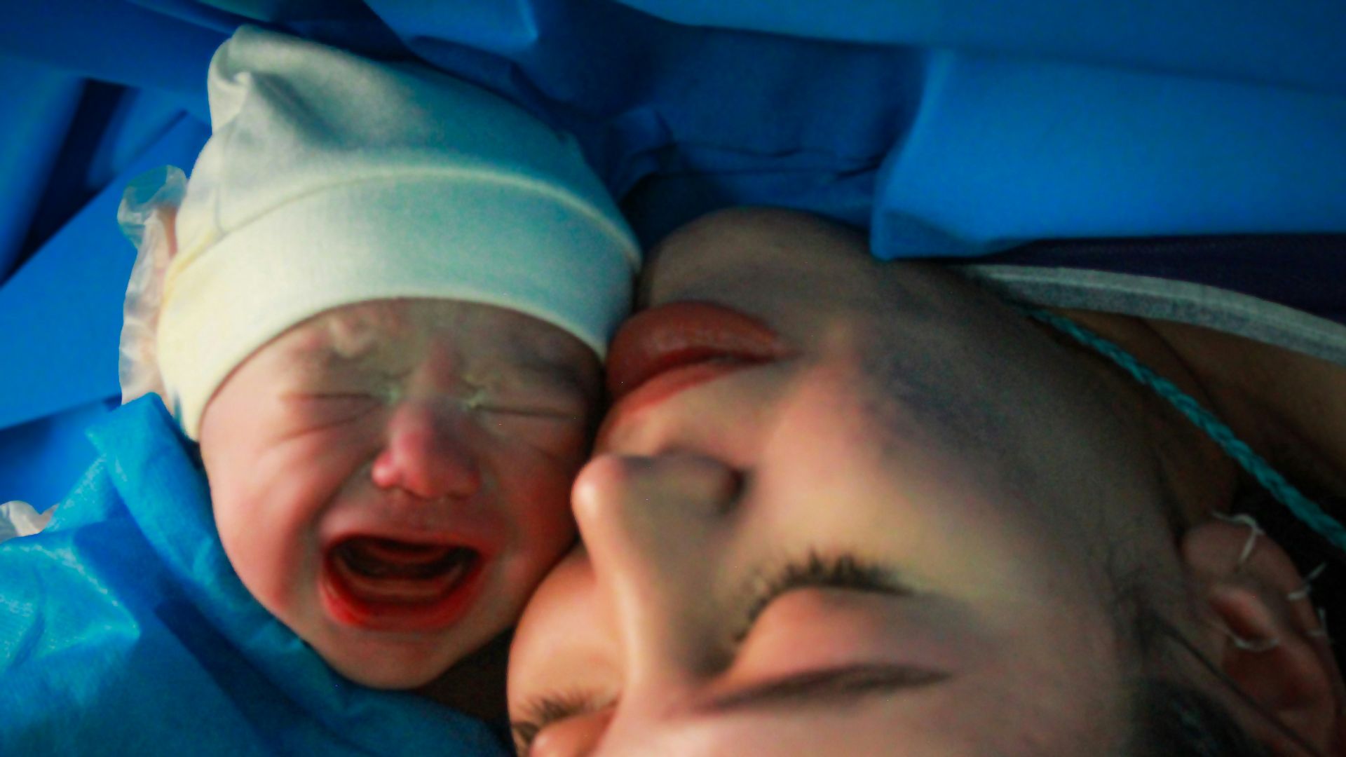 Mother and newborn share an intimate moment.