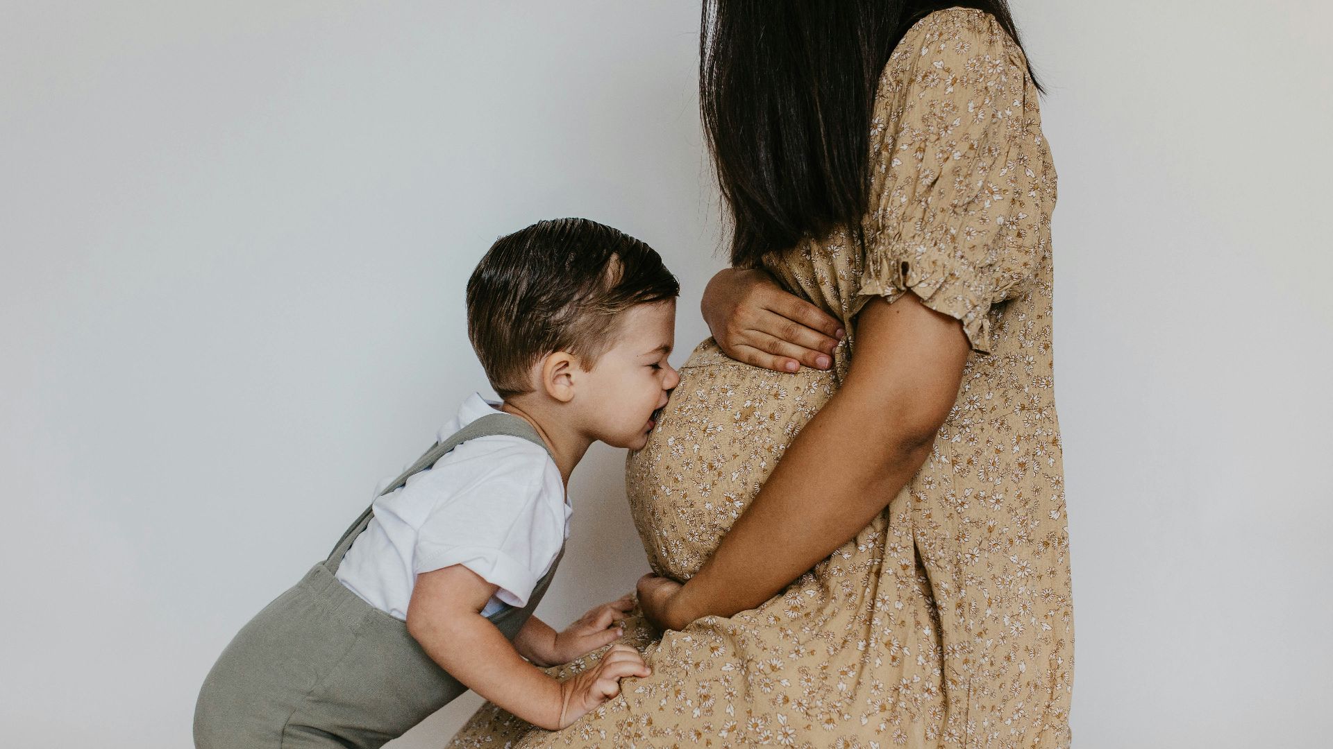 a woman holding a baby boy and kissing him