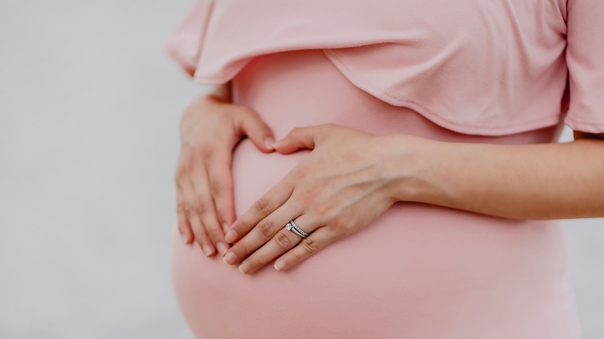 woman wearing gold ring and pink dress