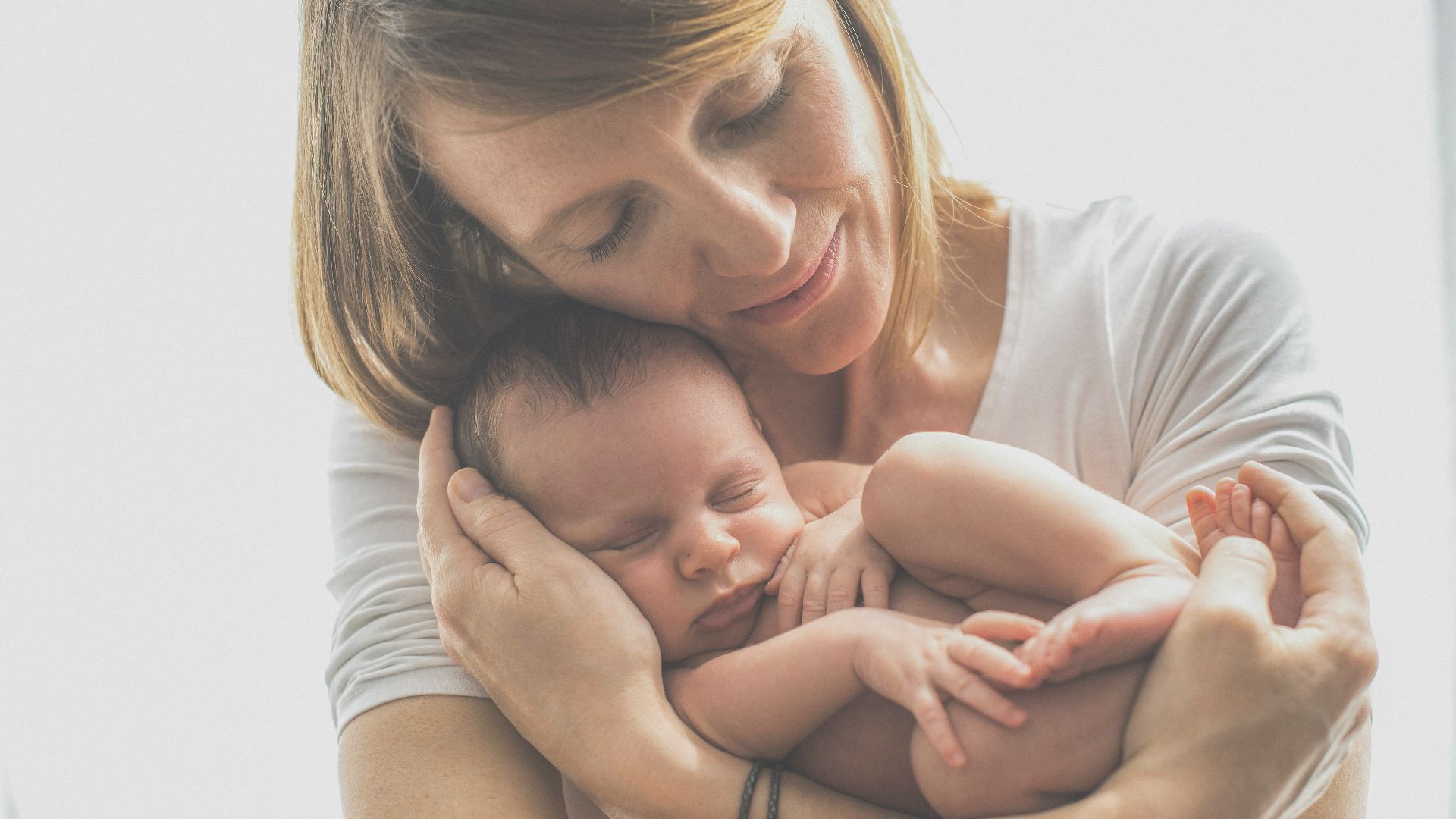 woman in white crew neck t-shirt carrying baby