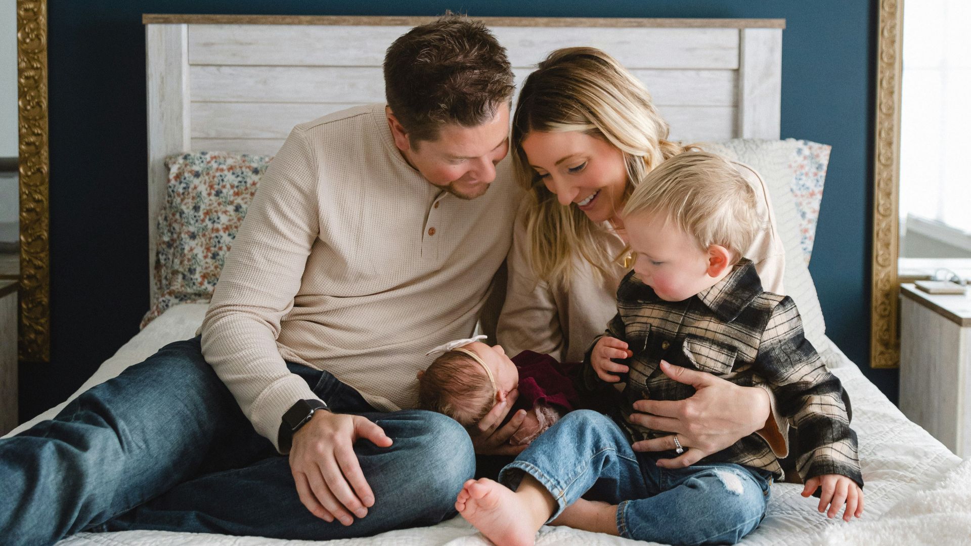 a man, woman, and child sitting on a bed