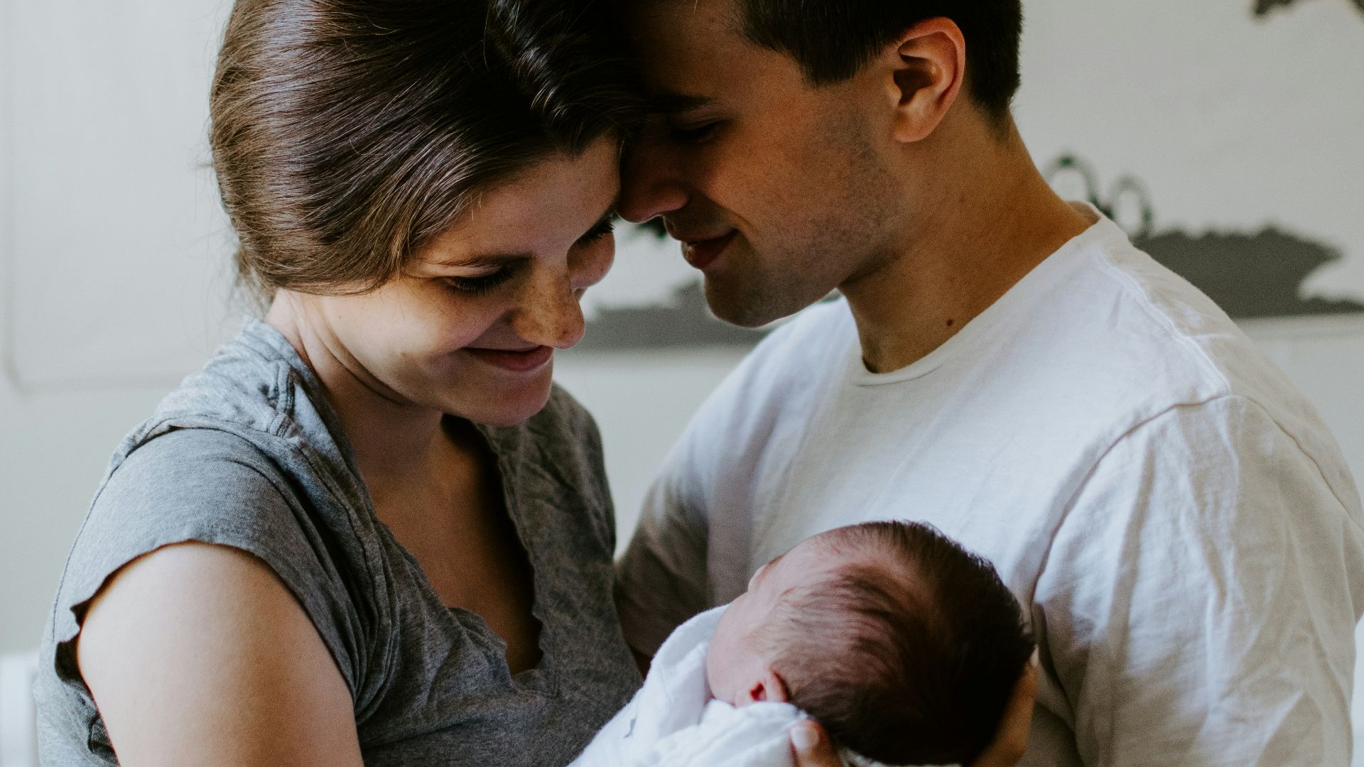 a man and woman holding a baby in their arms