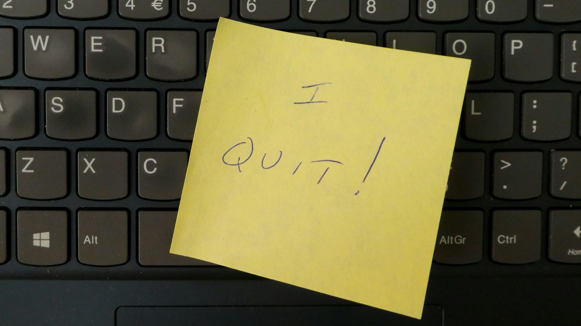 a yellow notepad on a keyboard