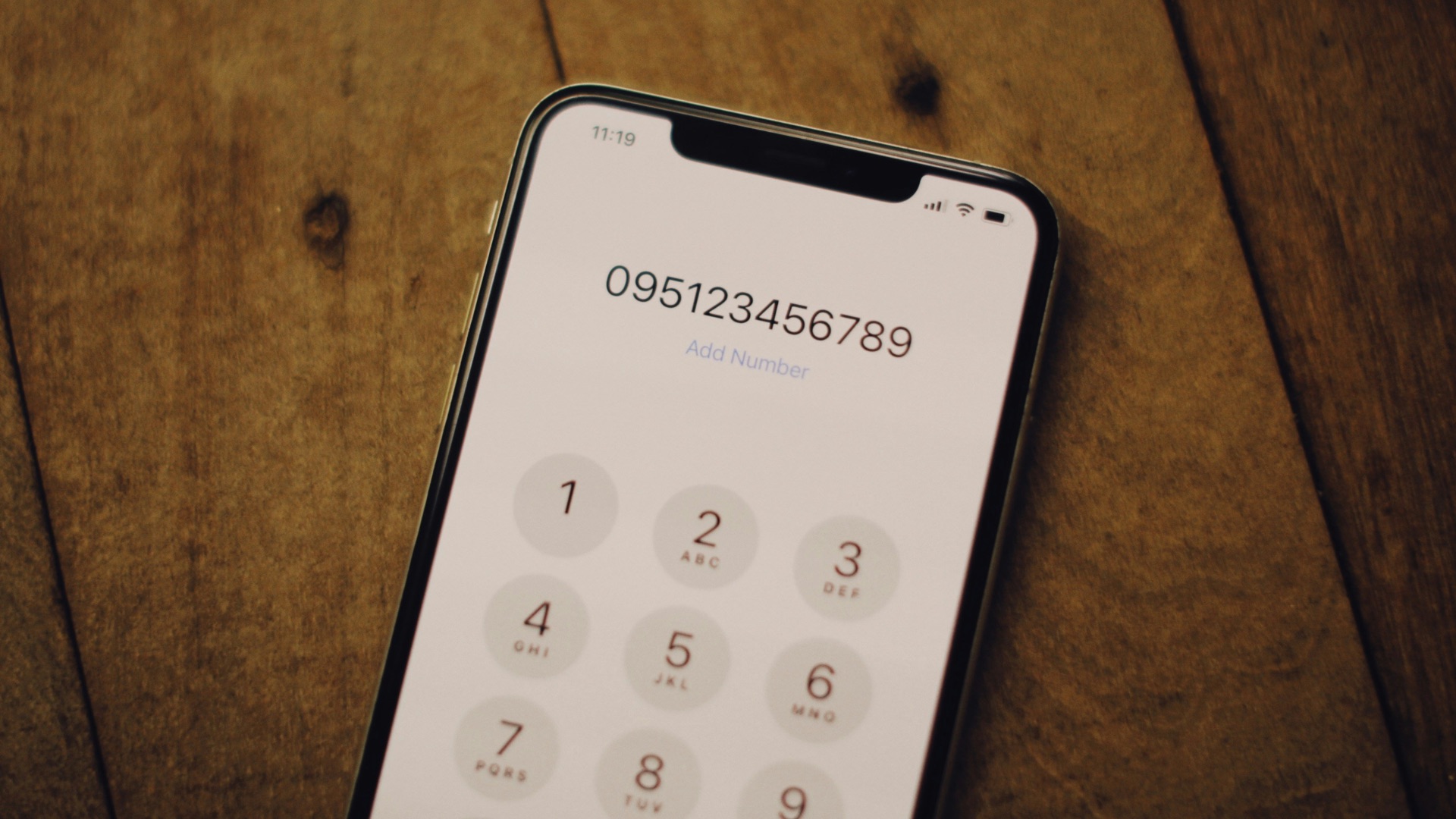 a cell phone sitting on top of a wooden table