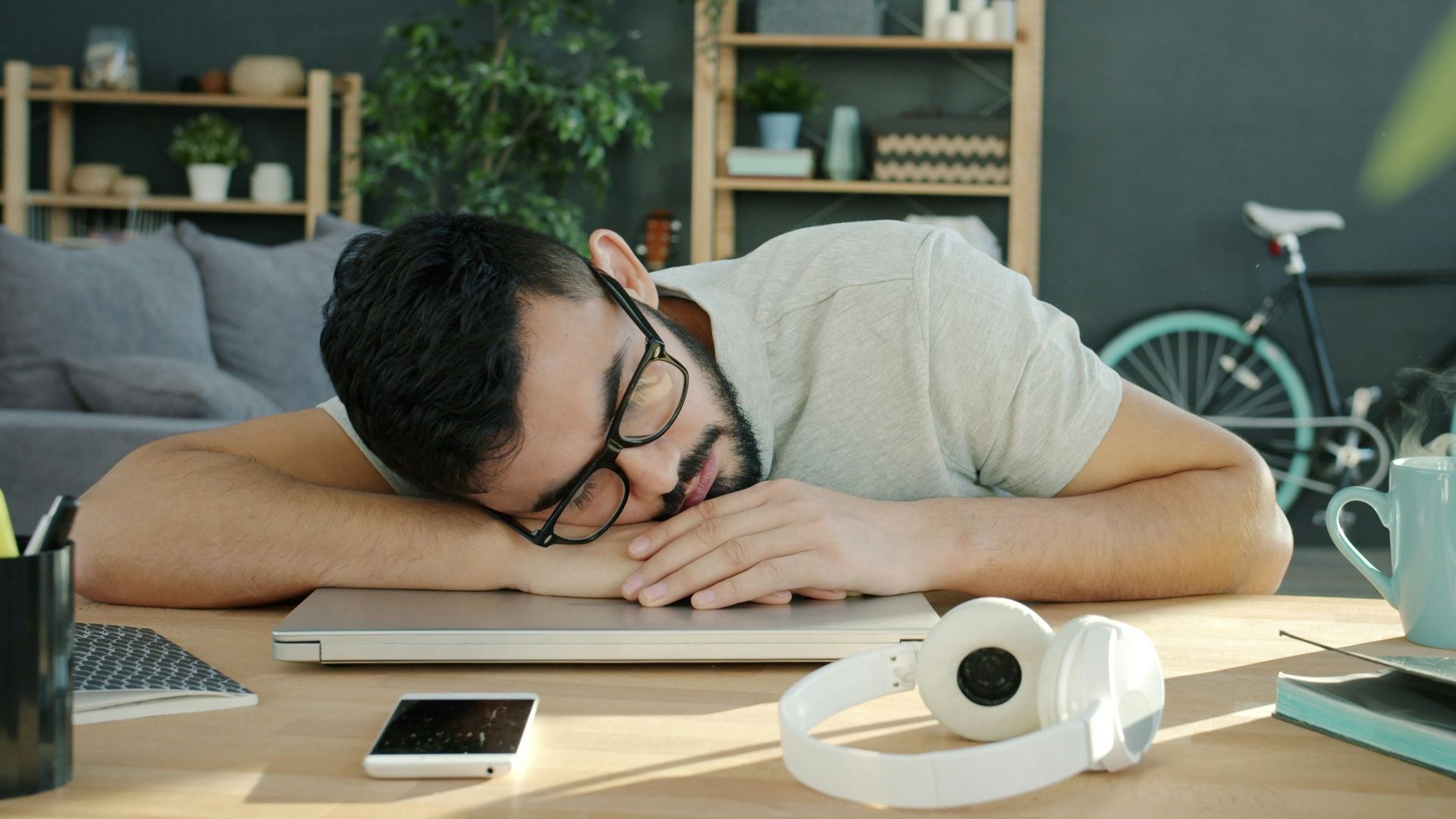 Man sleeping on a laptop at a desk