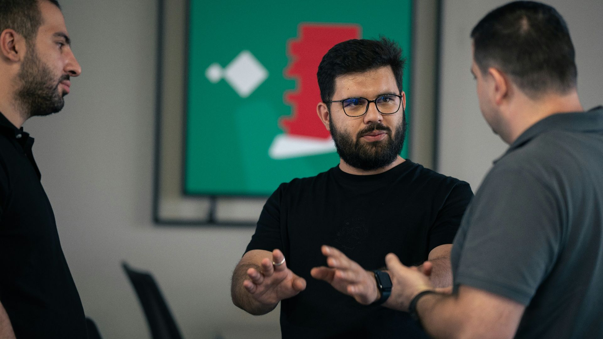 A group of men standing around each other in a room