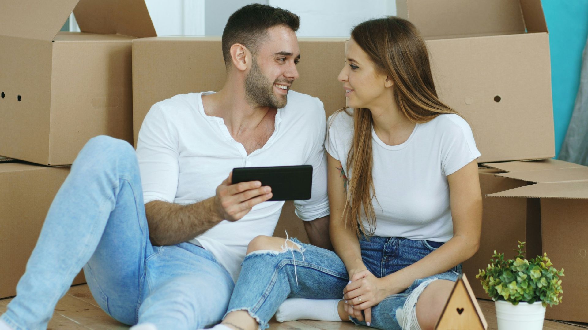 Couple looking at phone surrounded by moving boxes