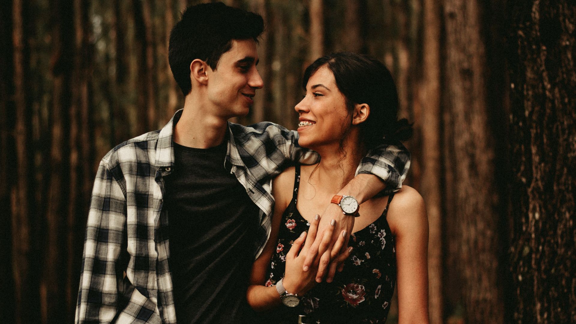 man wrapping arm on woman facing each other