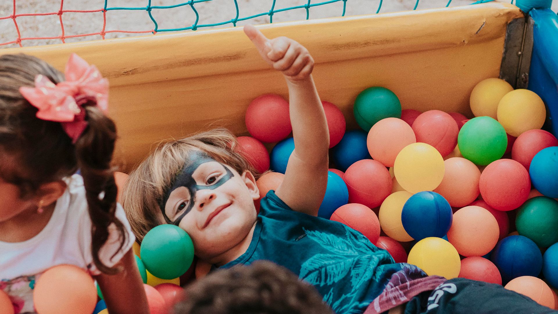 girl in blue shirt lying on yellow inflatable pool