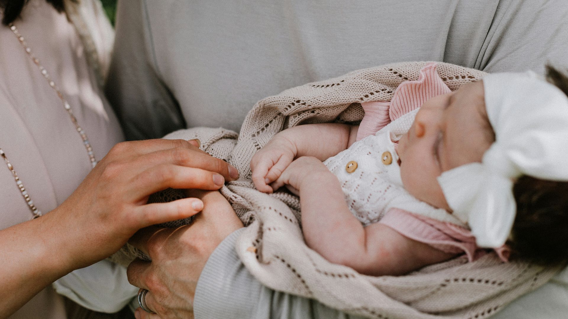 a woman holding a baby wrapped in a blanket