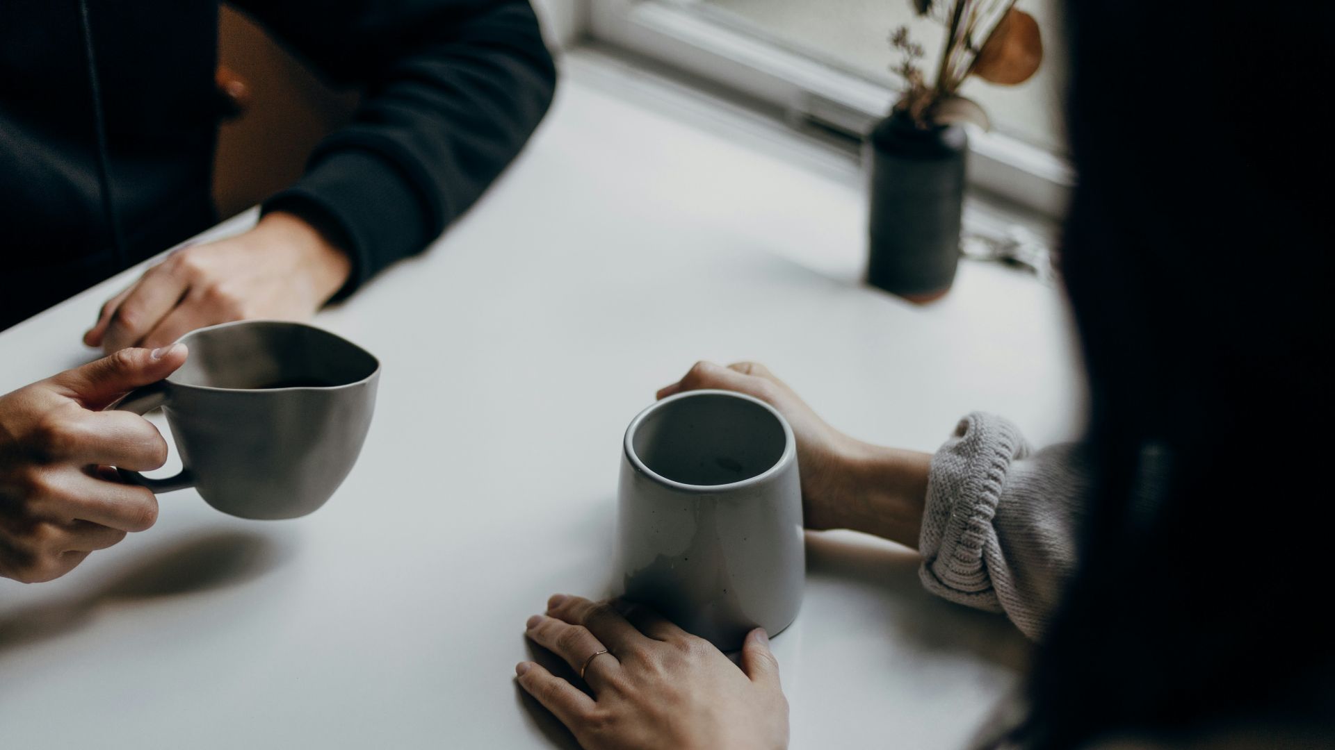woman in black long sleeve shirt holding black ceramic mug