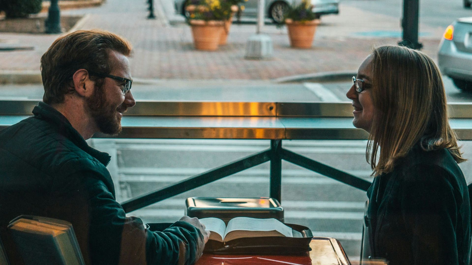 man and woman sitting while talking during daytime