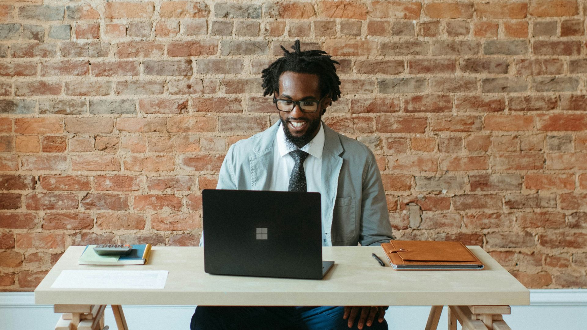 a man sitting at a table with a laptop on it