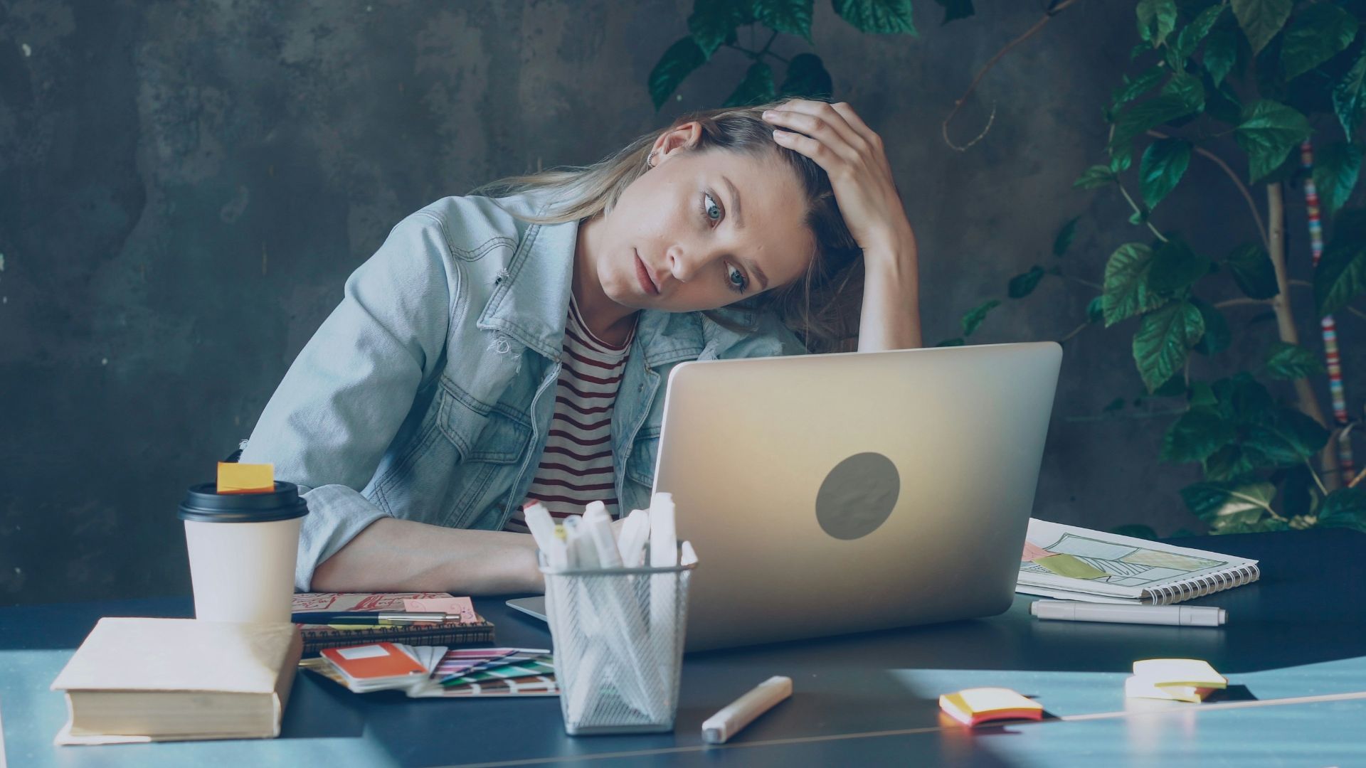 A woman appears stressed while working on laptop.
