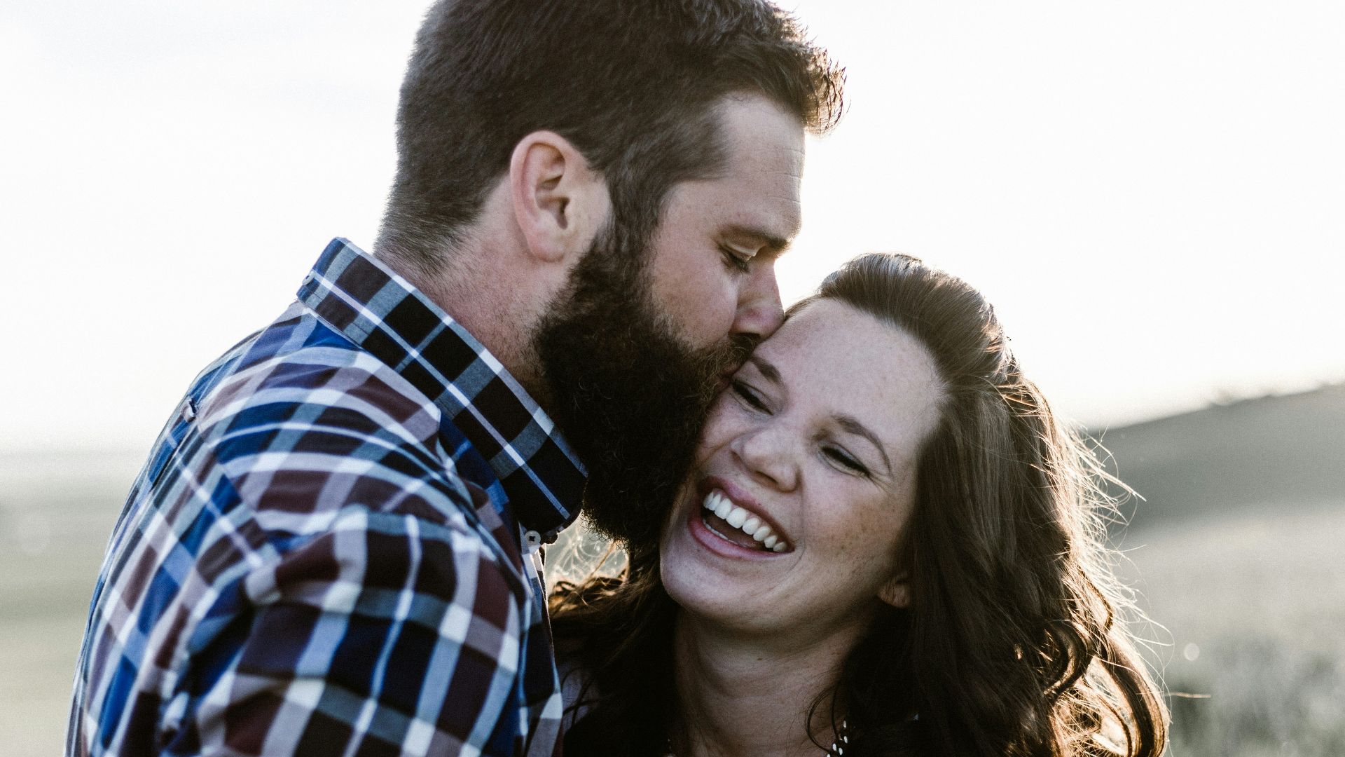 man kissing woman in grass area