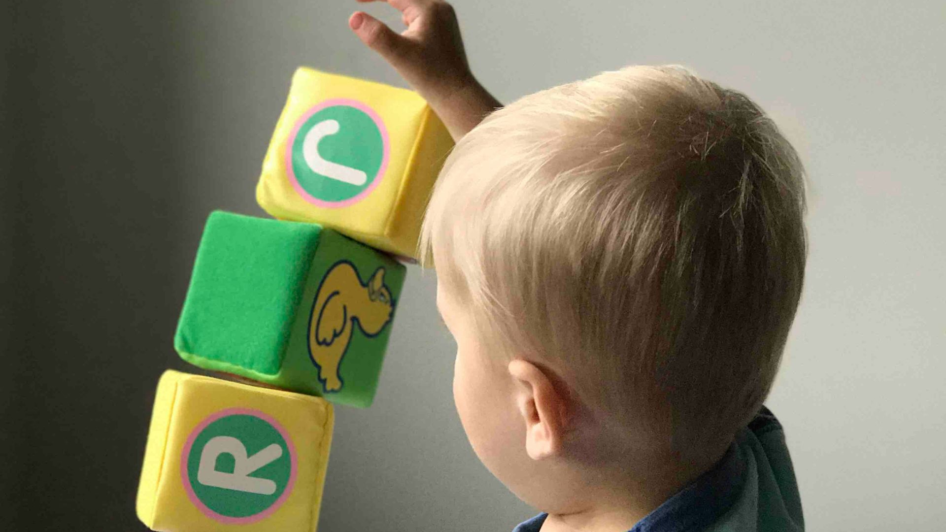 boy playing cube on white wooden table