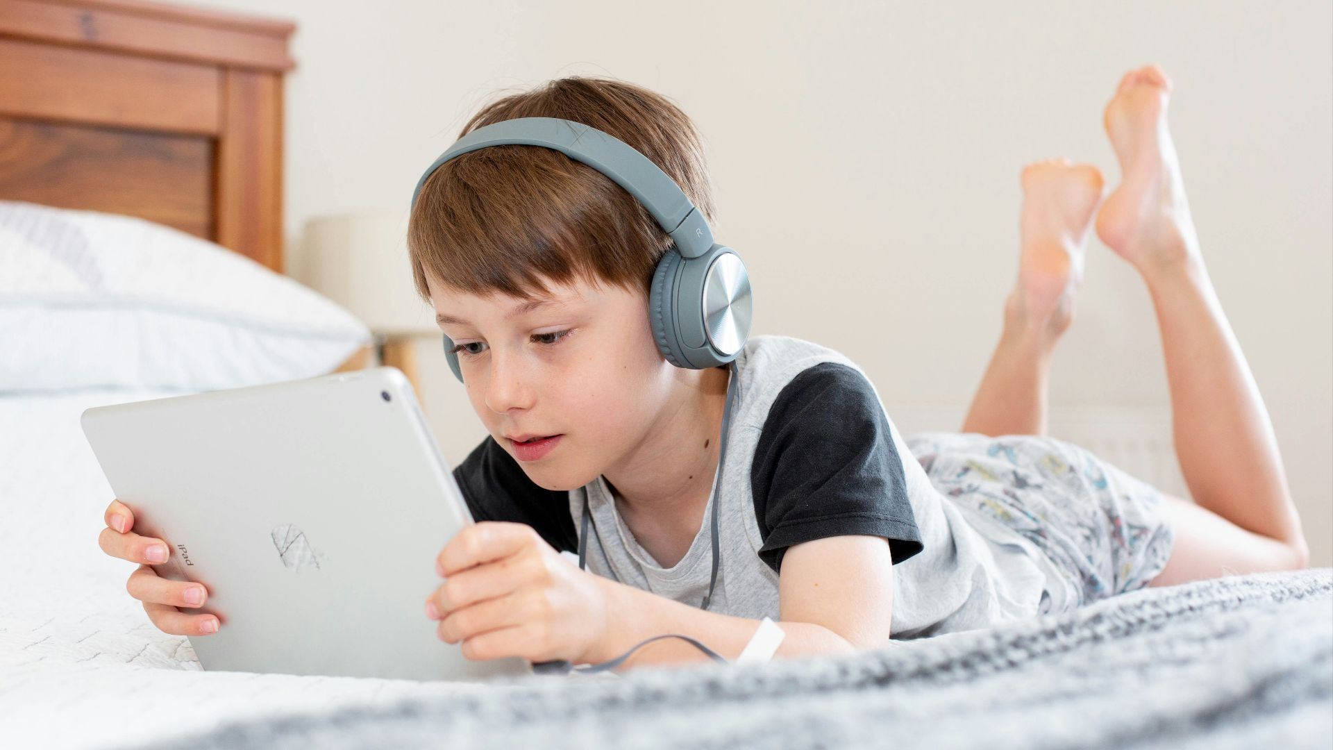 boy in black shirt using white laptop computer