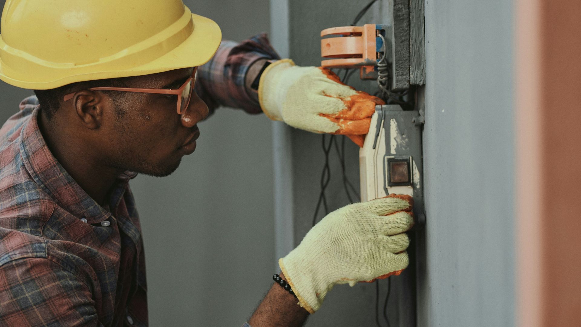 man in brown hat holding black and gray power tool