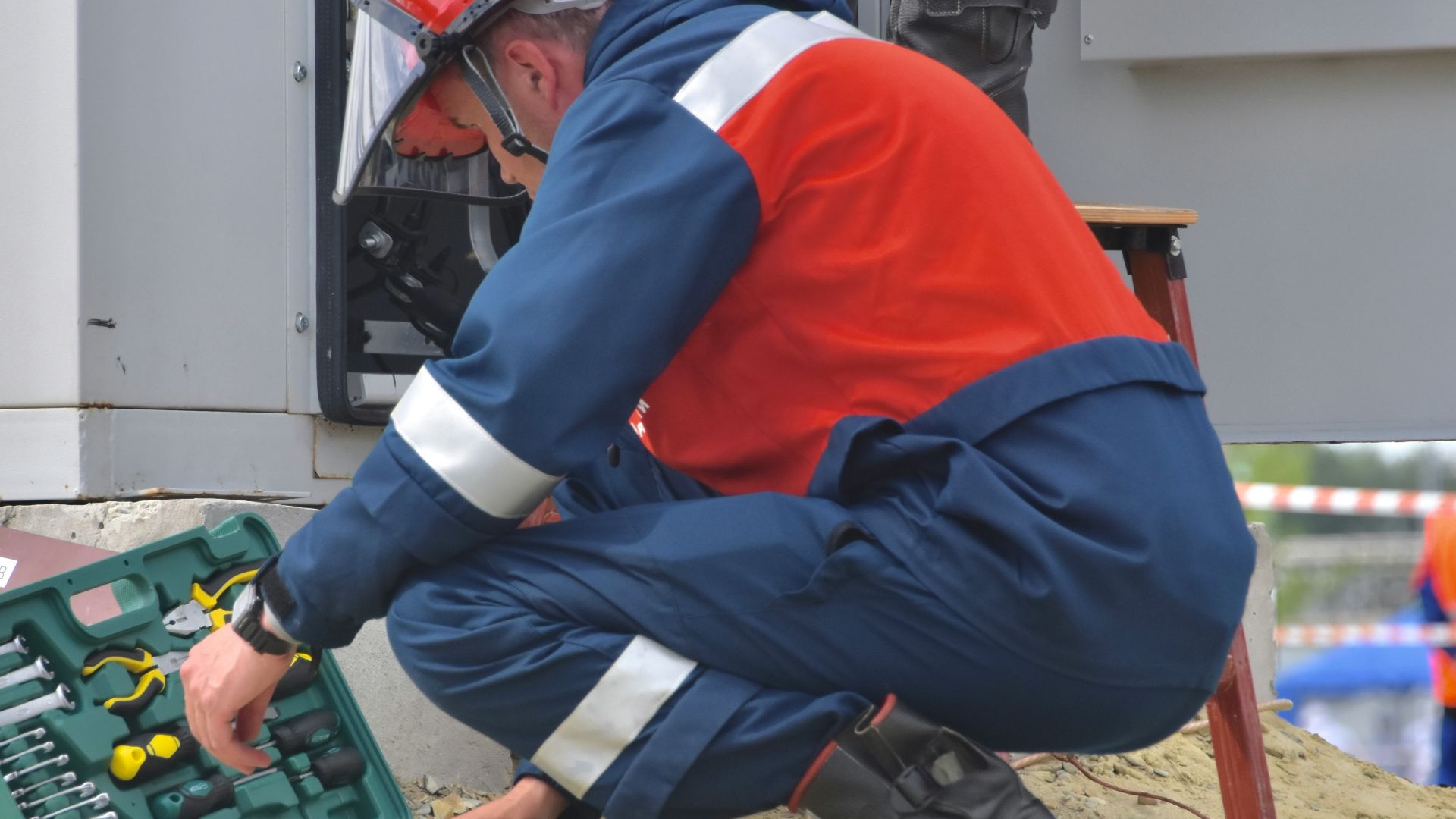 man in red and black jacket wearing black pants and red helmet holding green and black