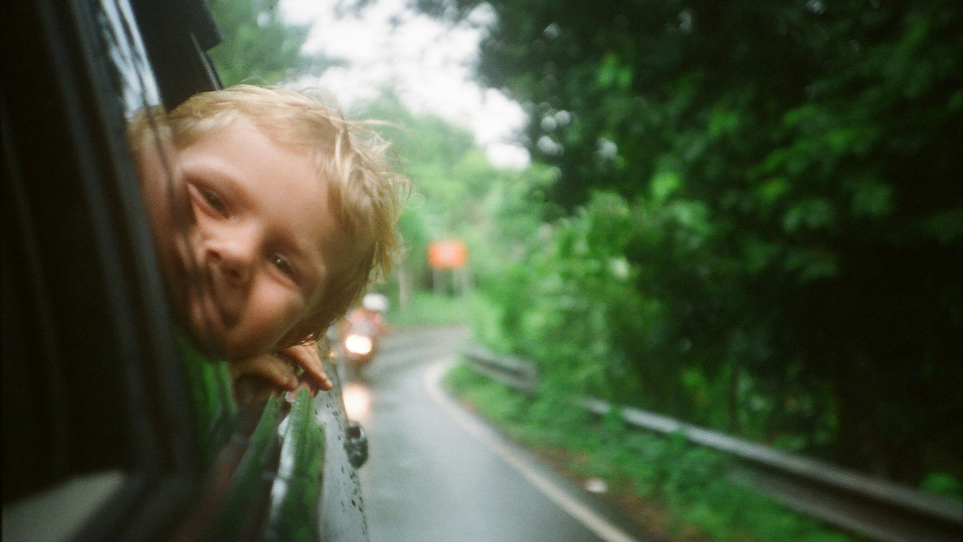 child peeking from vehicle window