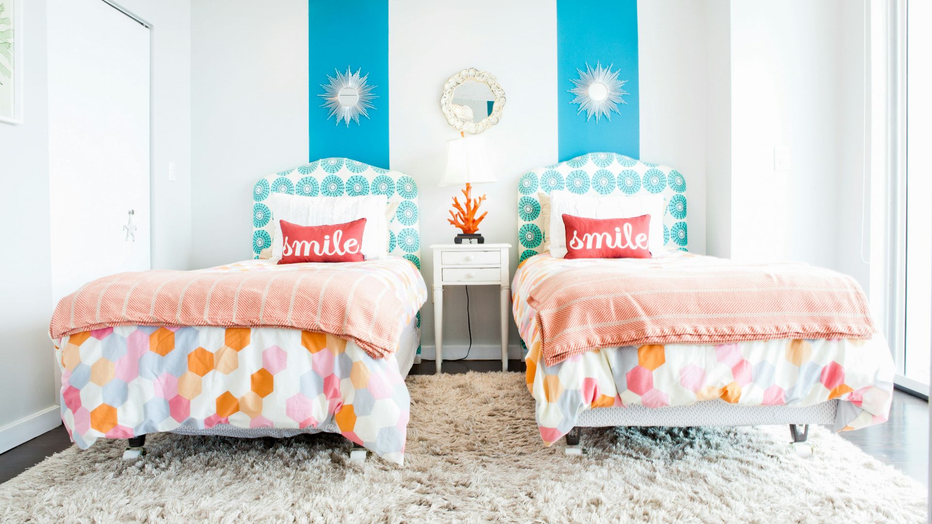 white and red throw pillows on white and blue floral bed