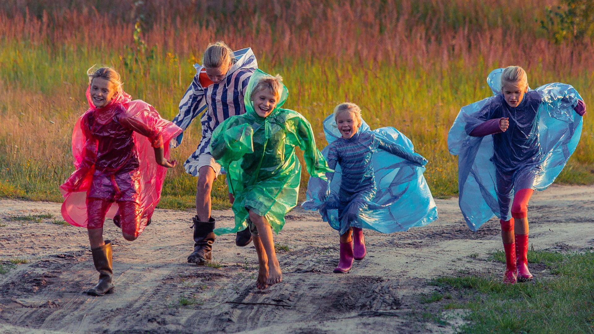 people in green and blue jacket walking on dirt road during daytime