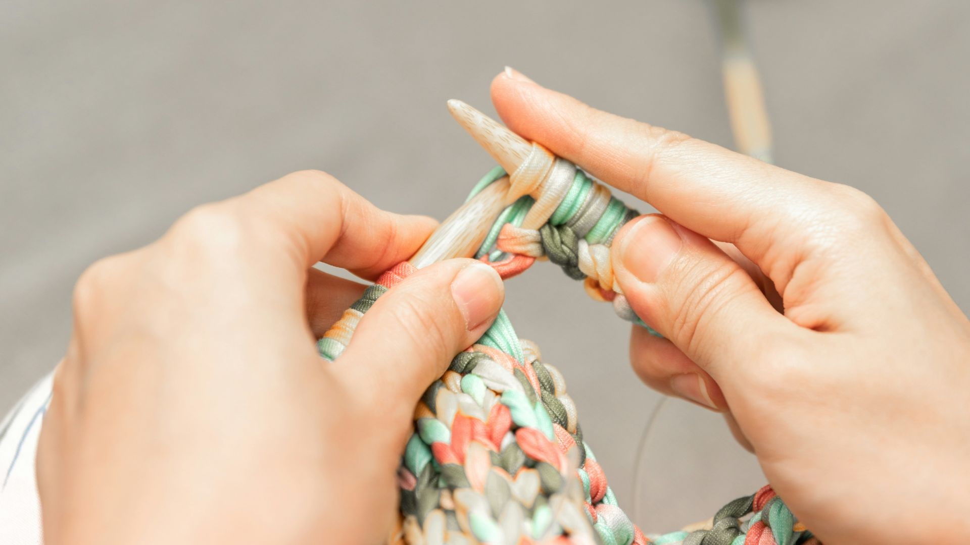 a woman is knitting a piece of fabric