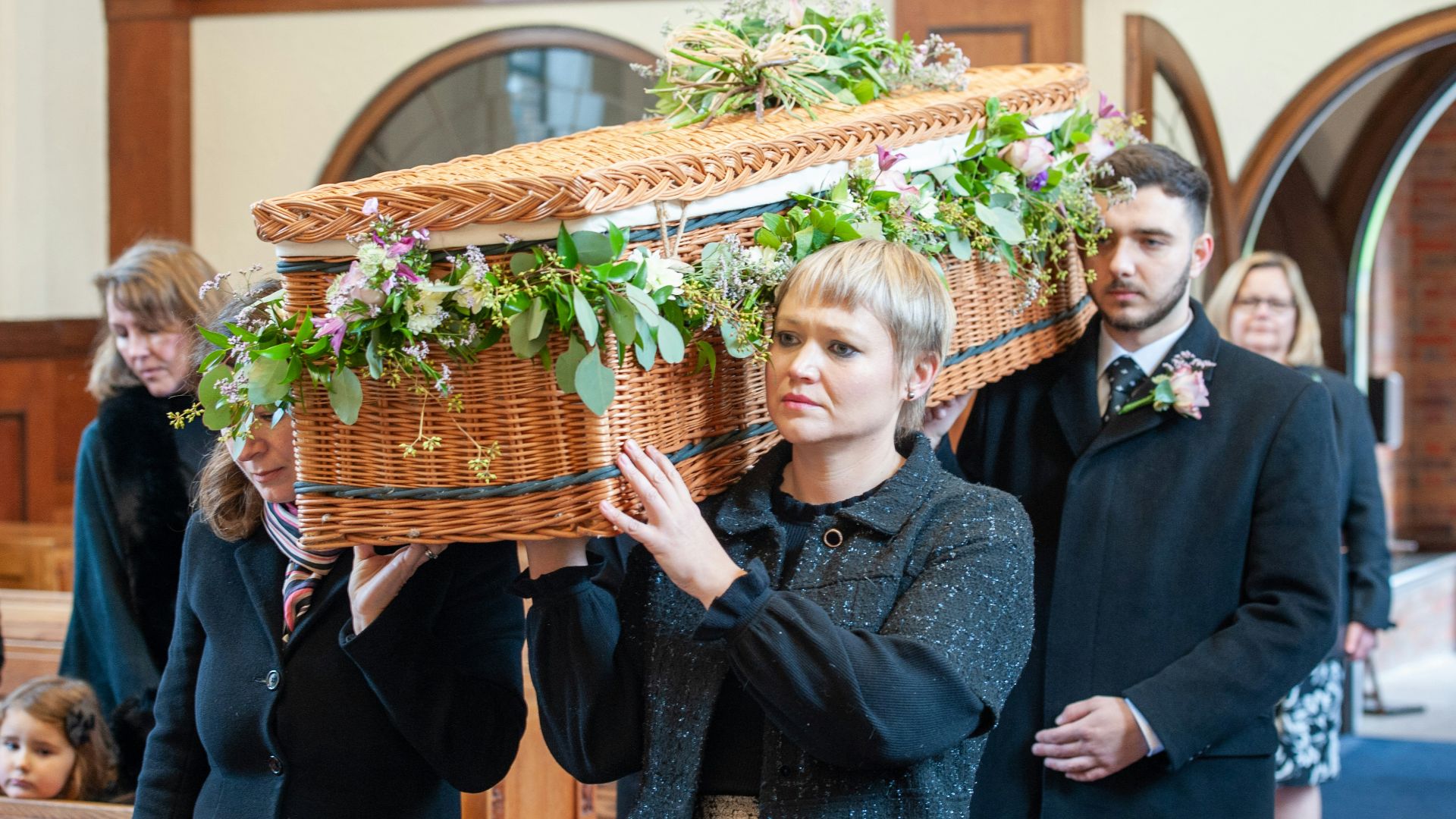 a woman holding a basket with flowers on it
