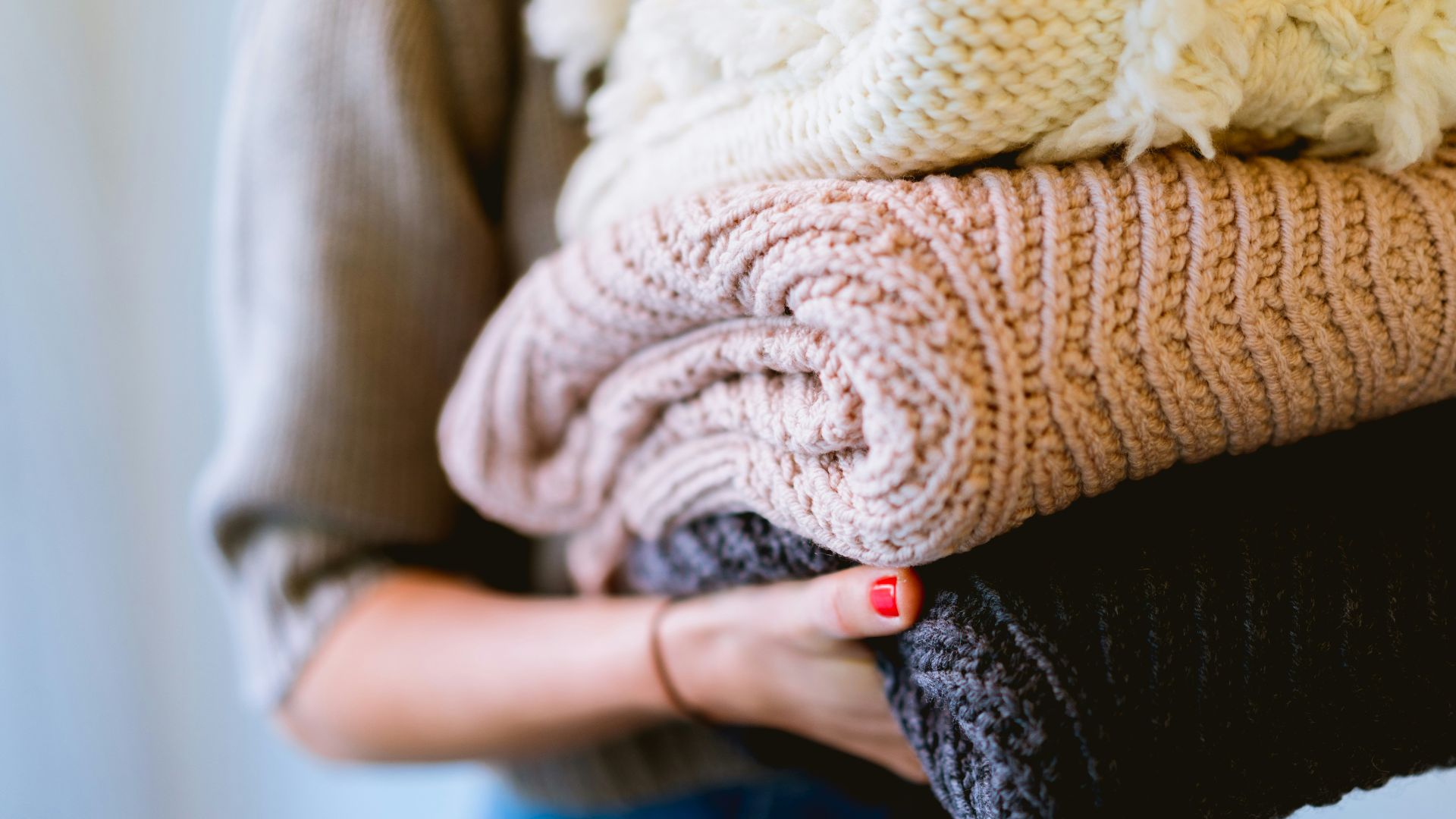 person holding knitted textiles