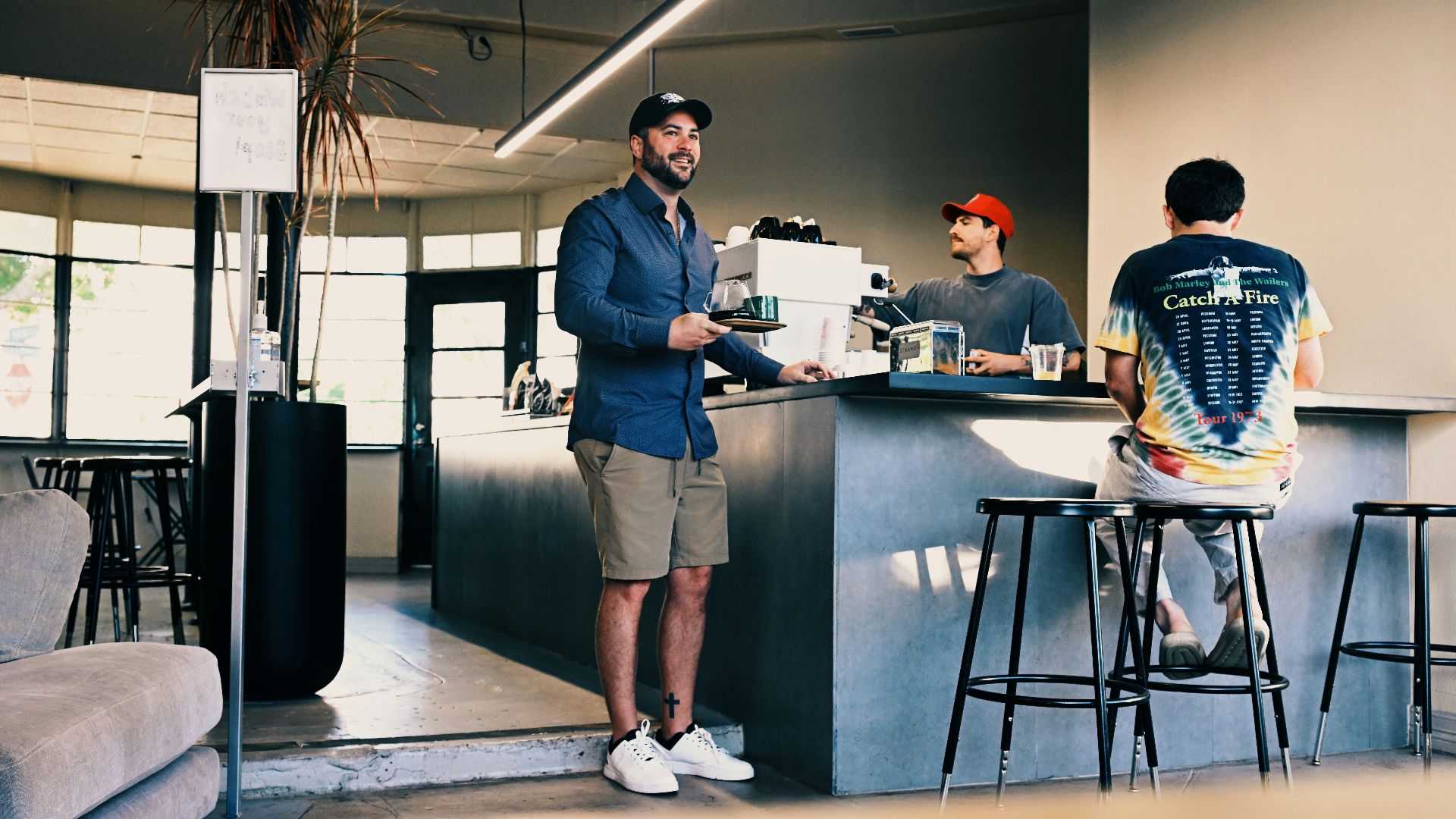 Man ordering coffee at a modern cafe counter.