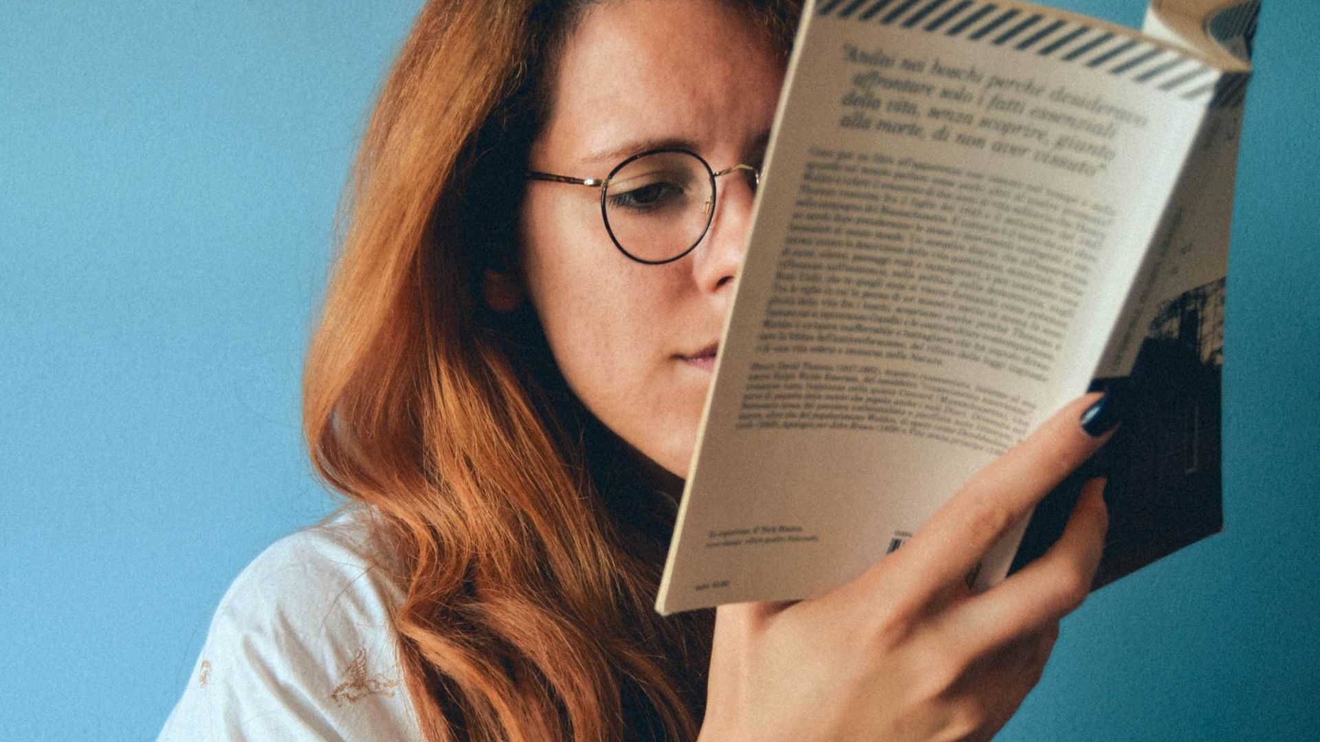 woman wearing eyeglasses holding a book