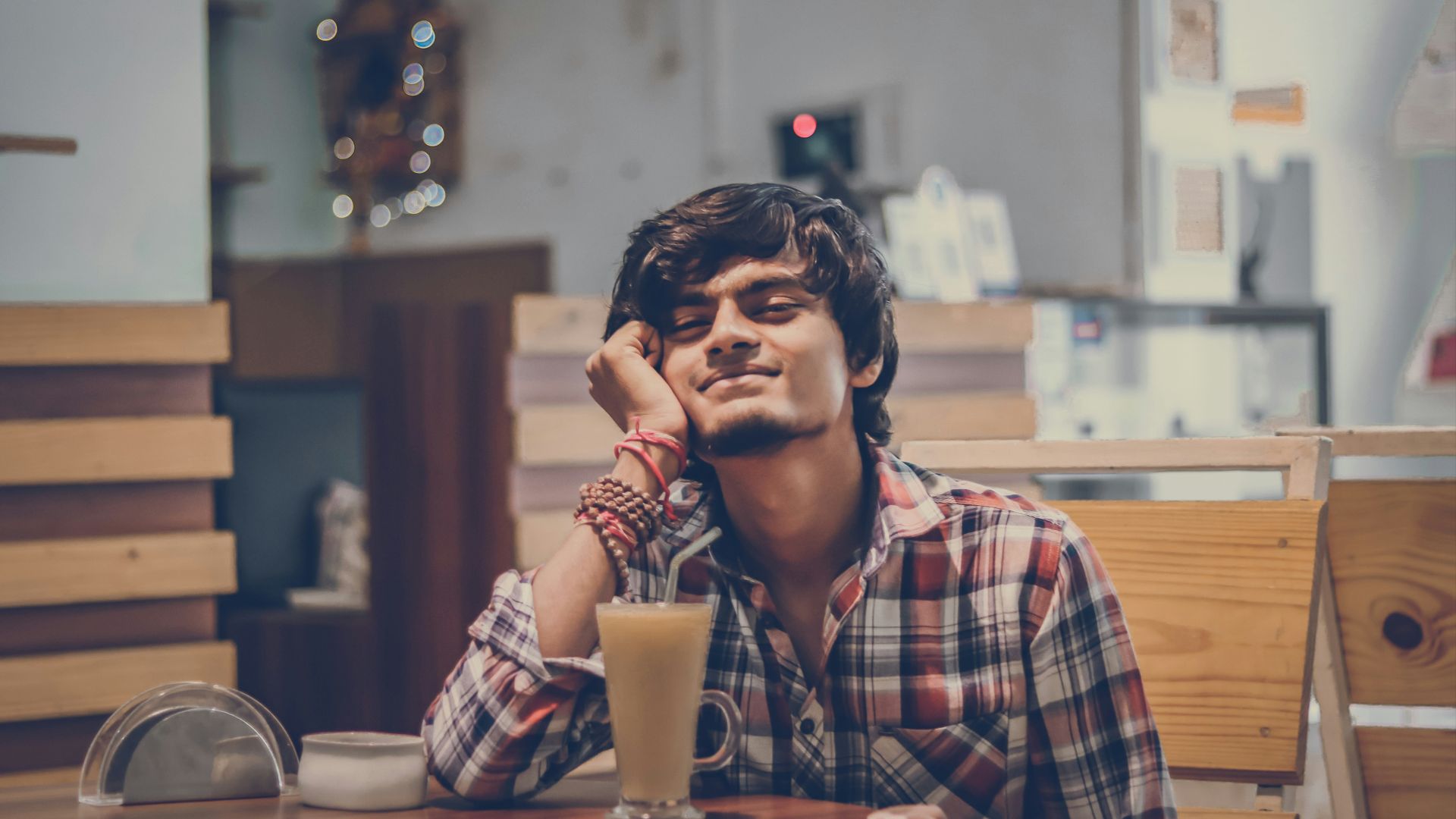 a man sitting at a table with a drink in front of him
