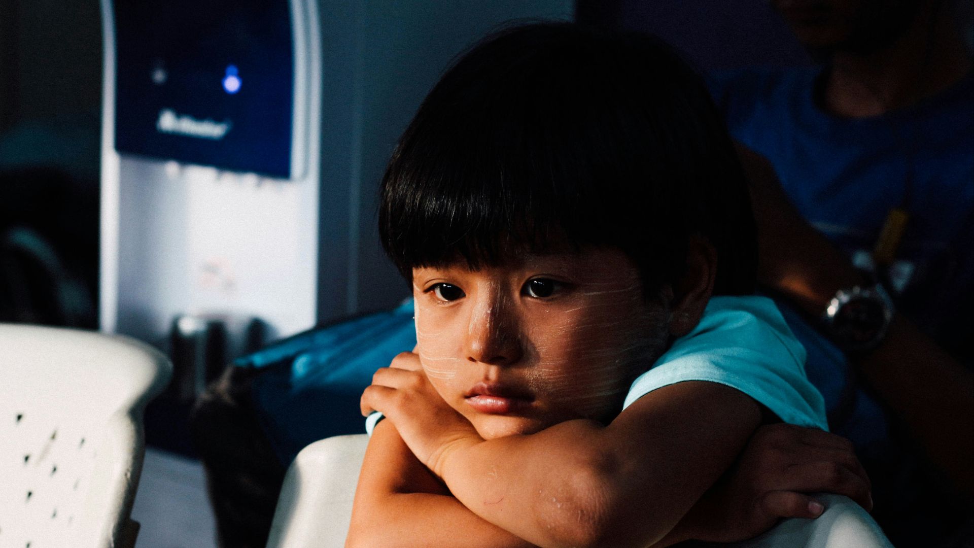 boy leaning on white chair